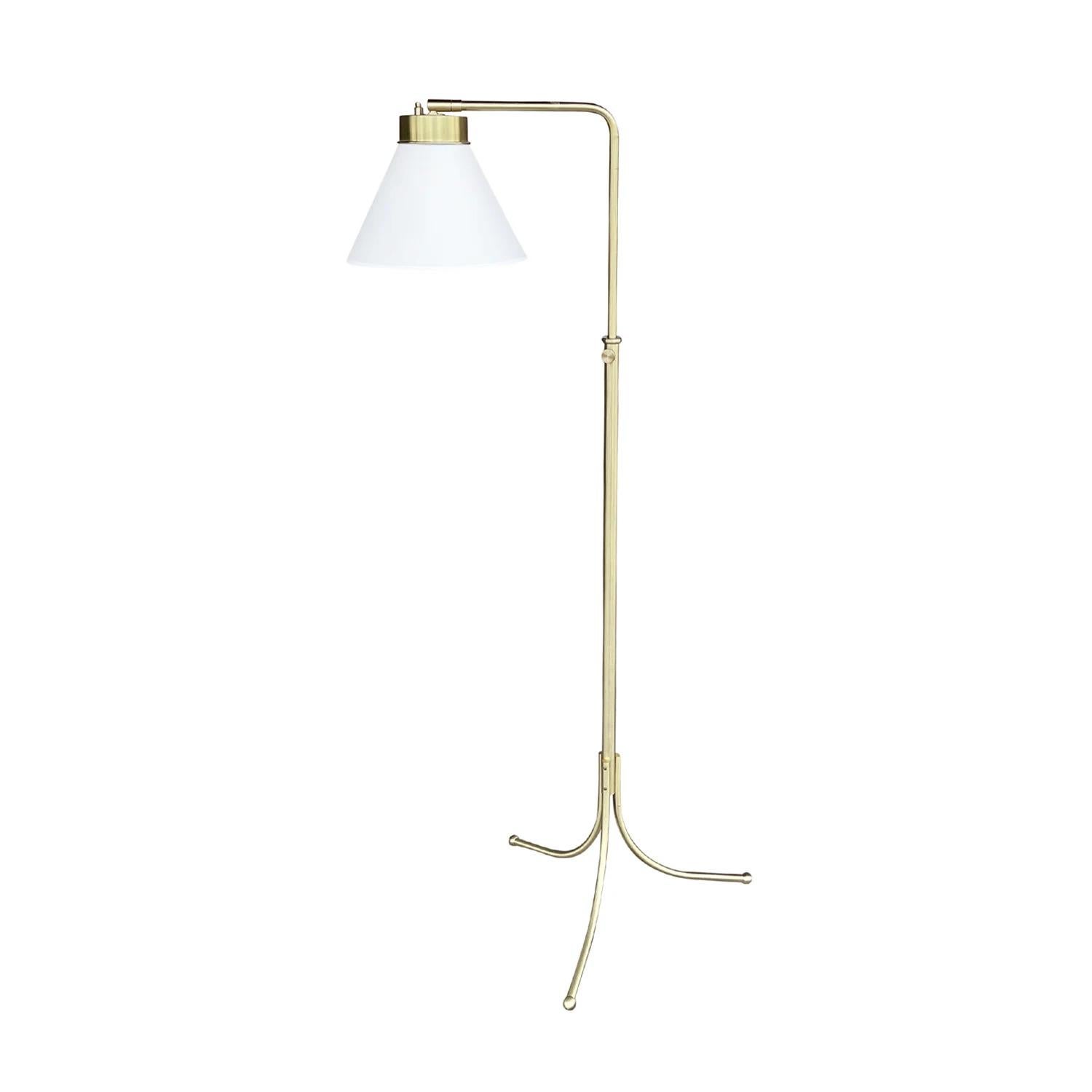A vintage Mid-Century Modern Swedish reading floor lamp with a new white round shade made of hand crafted polished brass, composed with its original light switch, designed by Josef Frank and produced by Svenskt Tenn in good condition. The shade of