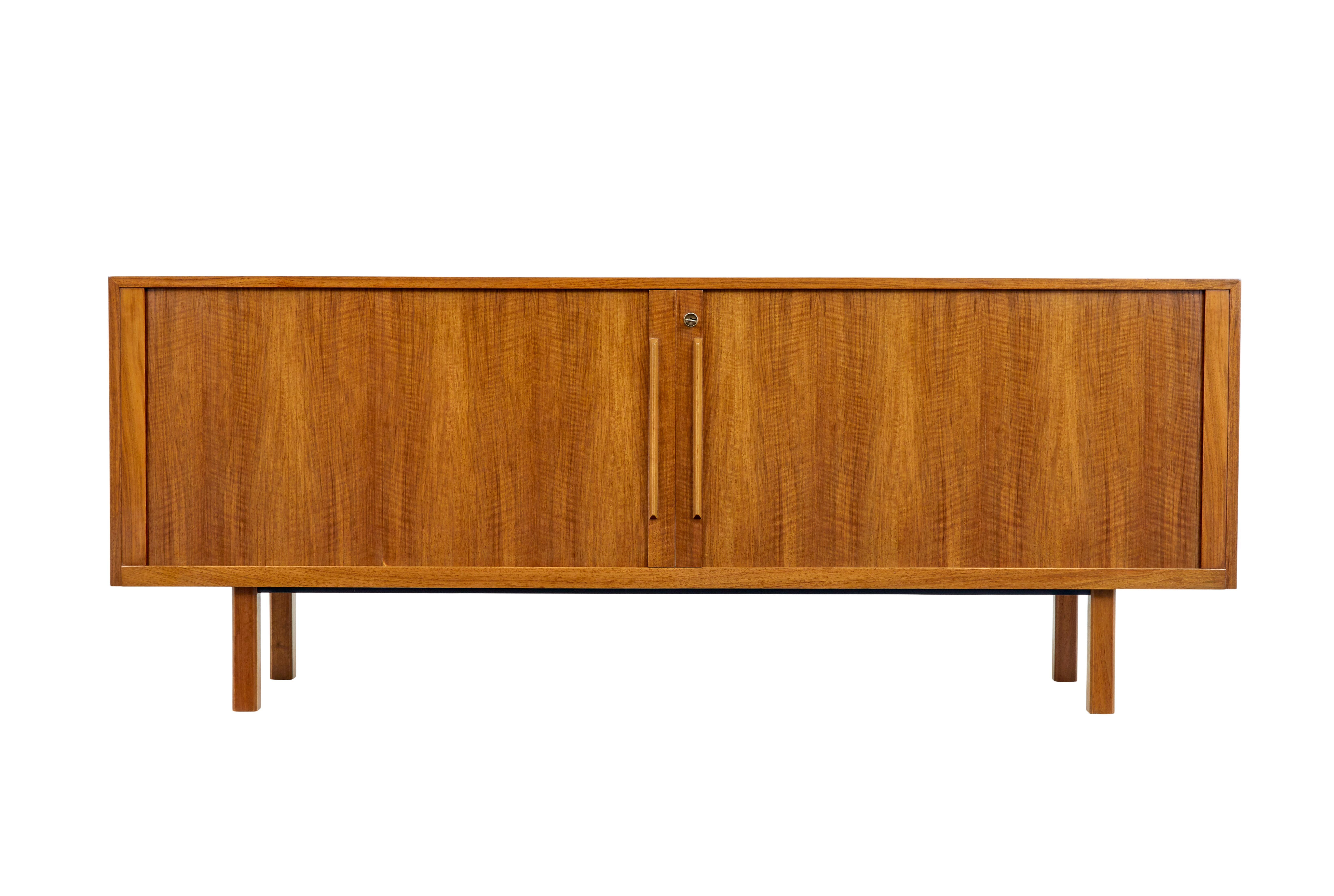 Good quality sideboard by Swedish makers Atvidabergs, circa 1965.

Tambour fronted which opens to reveal a semi fitted interior.

Three compartments, left hand side with a bank of six drawers, the other two sections with two drawers in the top (1