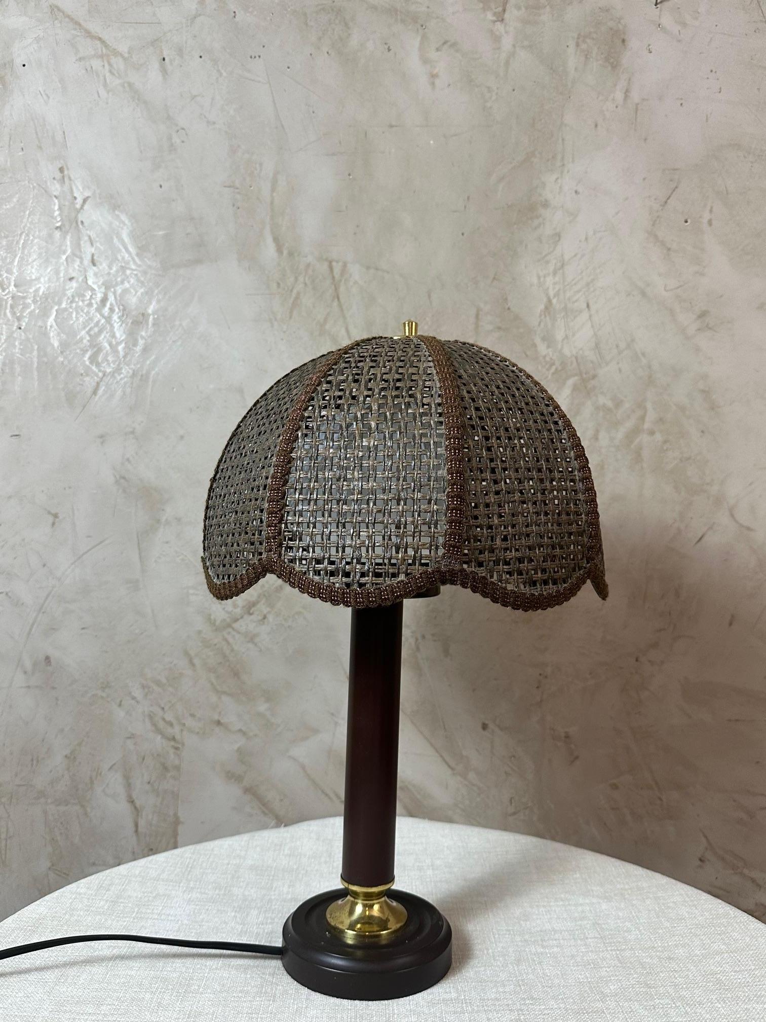 Beautiful 1970s lamp, created by a Swiss designer.
Its original woven bamboo dome-shaped shade combined with a sleek wooden and brass base gives it an elegant and distinctive look, typical of the design of that era.

Both decorative and functional,