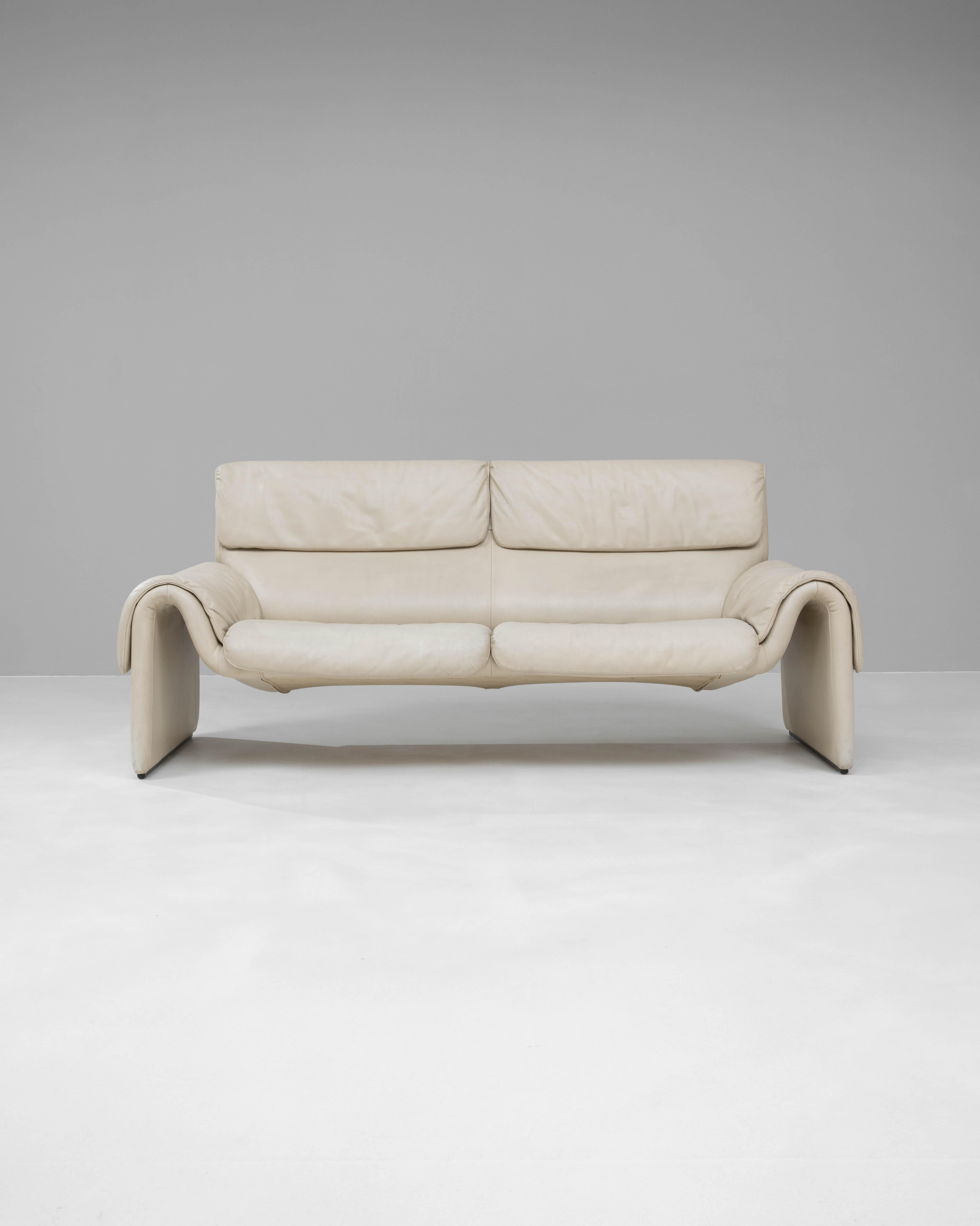 Ce canapé iconique DS2011 du fabricant suisse De Sede incarne le luxe et l'innovation en matière de design du milieu du XXe siècle. Tapissé de cuir crème de haute qualité, le canapé offre une silhouette élégante et profilée avec des accoudoirs