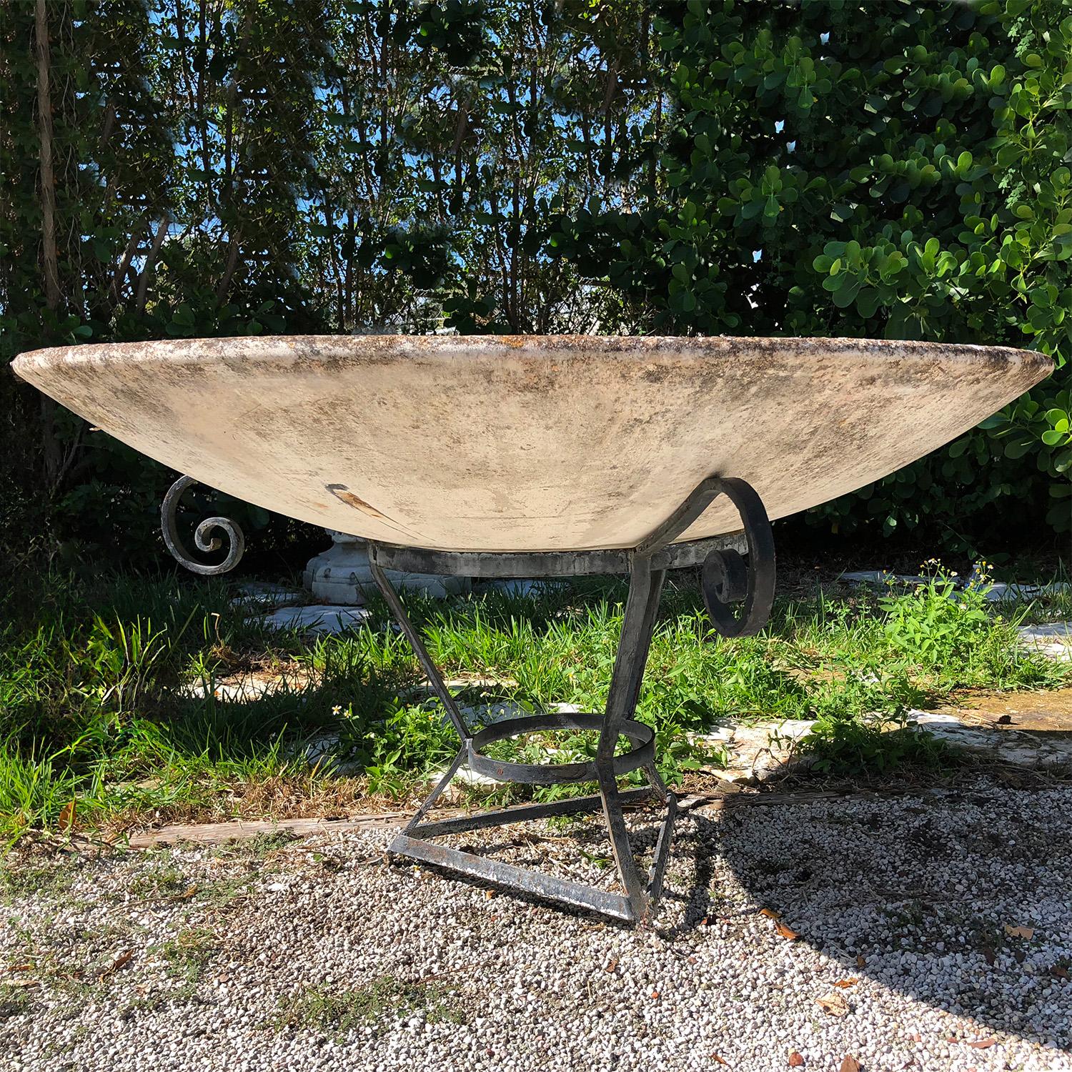 Gran jardinera de platillo suizo de mediados del siglo XX, hecha a mano con cemento ligero, diseñada por Willy Guhl y fabricada por Eternit, en buen estado. El adorno de jardín se eleva sobre un soporte de hierro forjado. Superficie envejecida