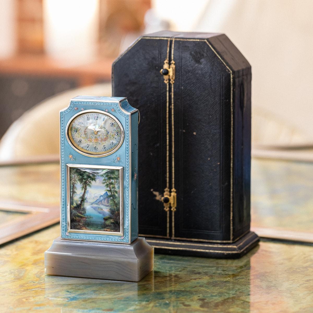 Antique early 20th century swiss solid silver and guilloché enamel travel clock or boudoir clock, in neoclassical taste, of upright rectangular form with inverted arched top and standing on a raised grey agate plinth, applied with a translucent