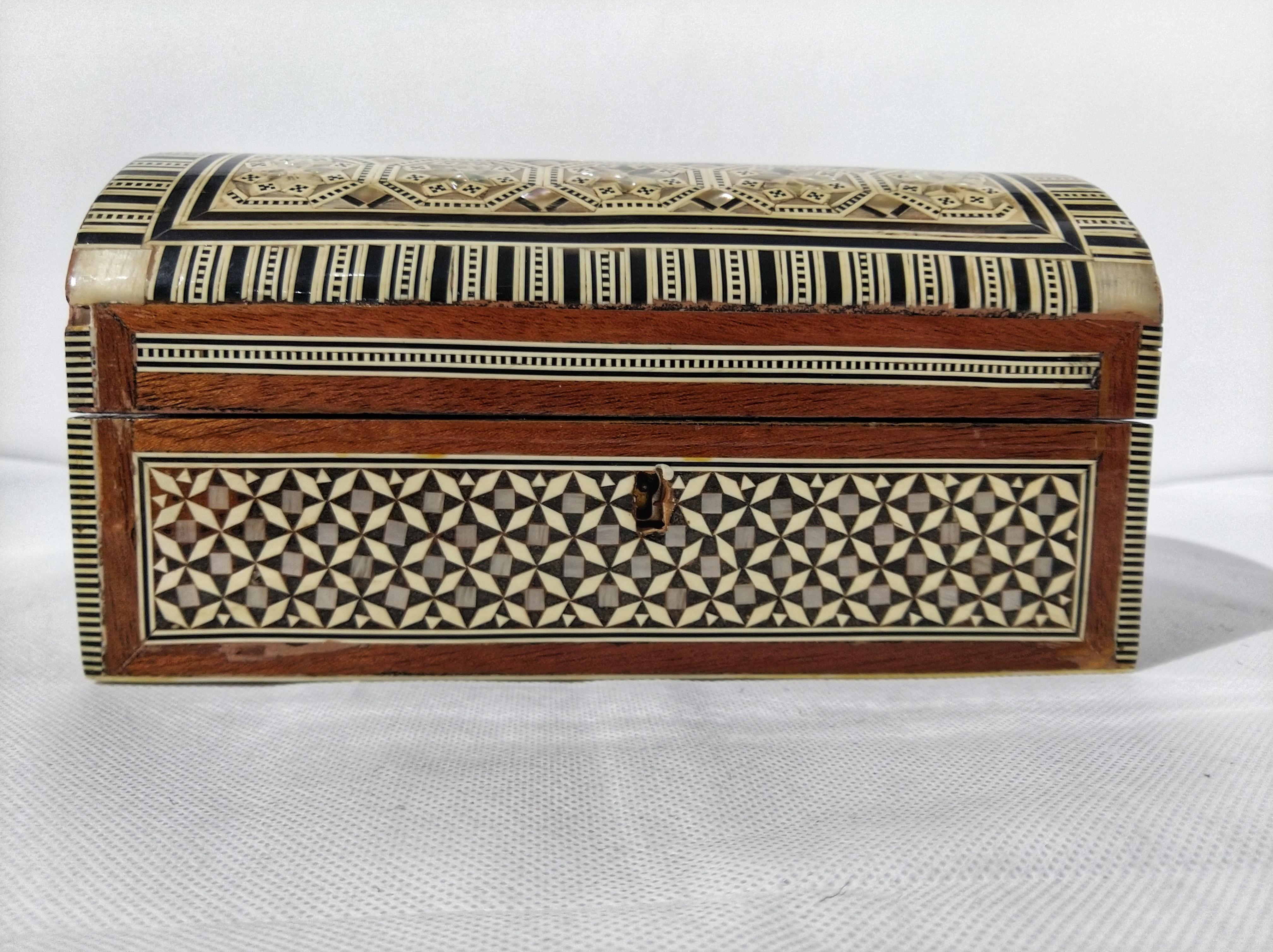 Exquisite handcrafted Middle Eastern Syrian mother of pearl inlaid walnut wood jewelry box.
Large dome jewelry chest intricately decorated with Moorish motif designs which have been painstakingly inlaid with mother of pearl and bone and marquetry