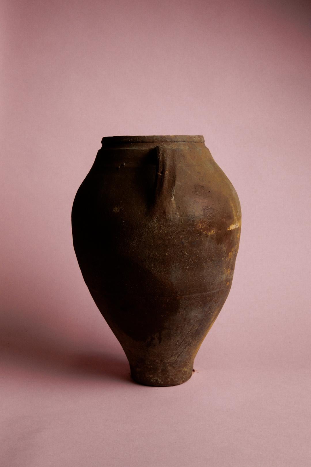 Infondi nel tuo spazio il fascino senza tempo del Mediterraneo grazie a questo vaso conico in argilla egea, un notevole manufatto del XX secolo proveniente dalla regione dell'Egeo, famosa per le sue magistrali tradizioni ceramiche. Originariamente
