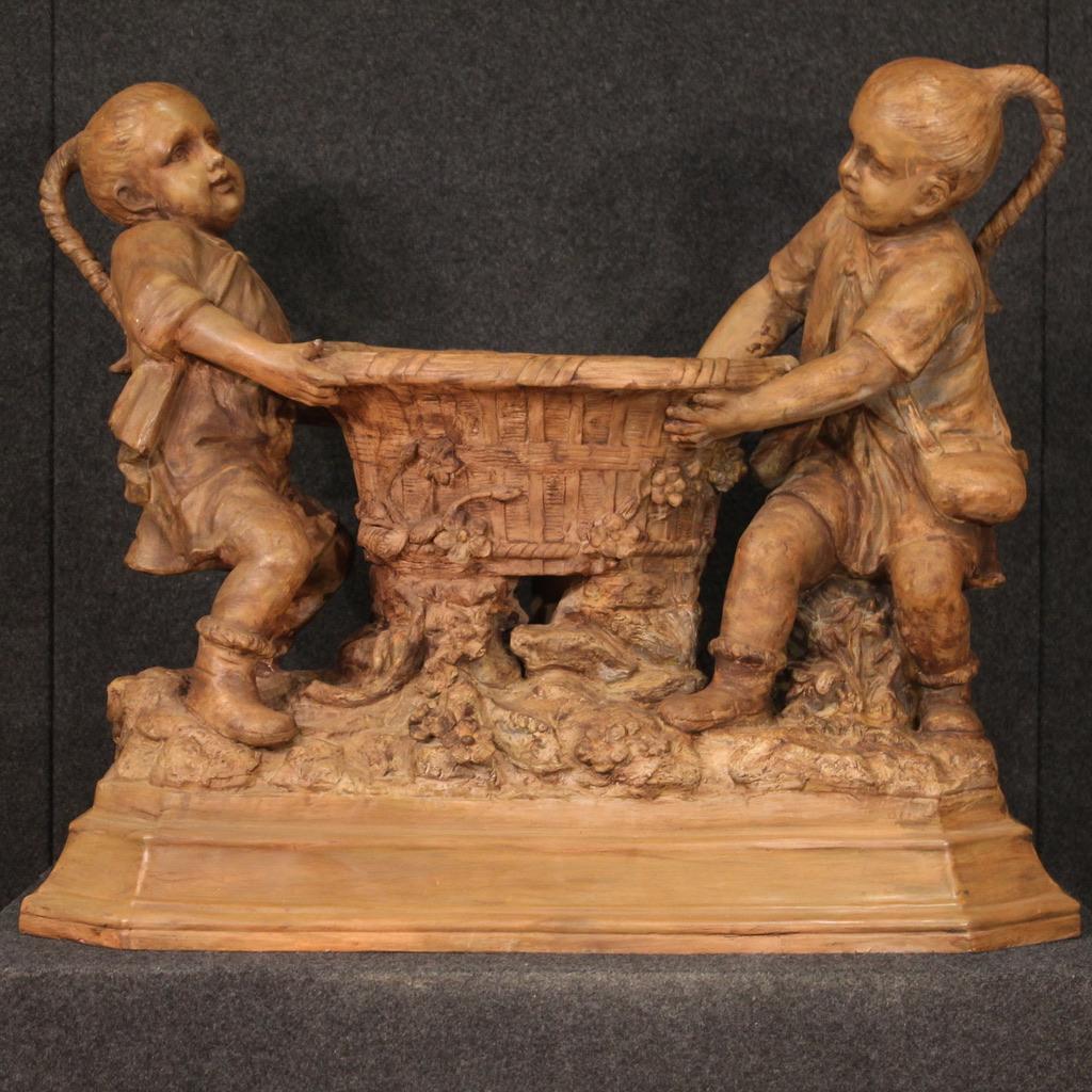 Große österreichische Skulptur aus dem 20. Jahrhundert. Terrakotta-Vase, getragen von zwei Kindern auf einem achteckigen Sockel. Skulptur im orientalischen Stil, bis ins kleinste Detail ausgearbeitet, von der Kleidung der Kinder bis zur Verzierung