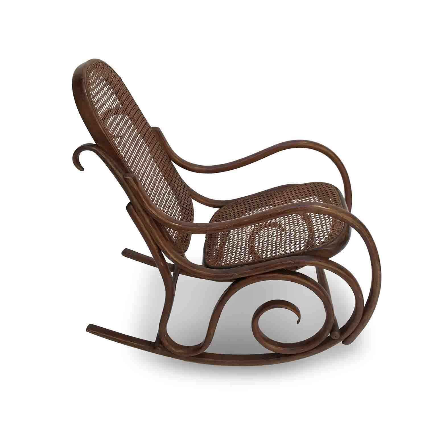 A lovely 20th century Thonet style beech bentwood child’s rocking chair with cane back and seat in fair age related condition, featuring bent curls and a beautiful original patina. A minor cane small defect in the upper profile and a crack in the