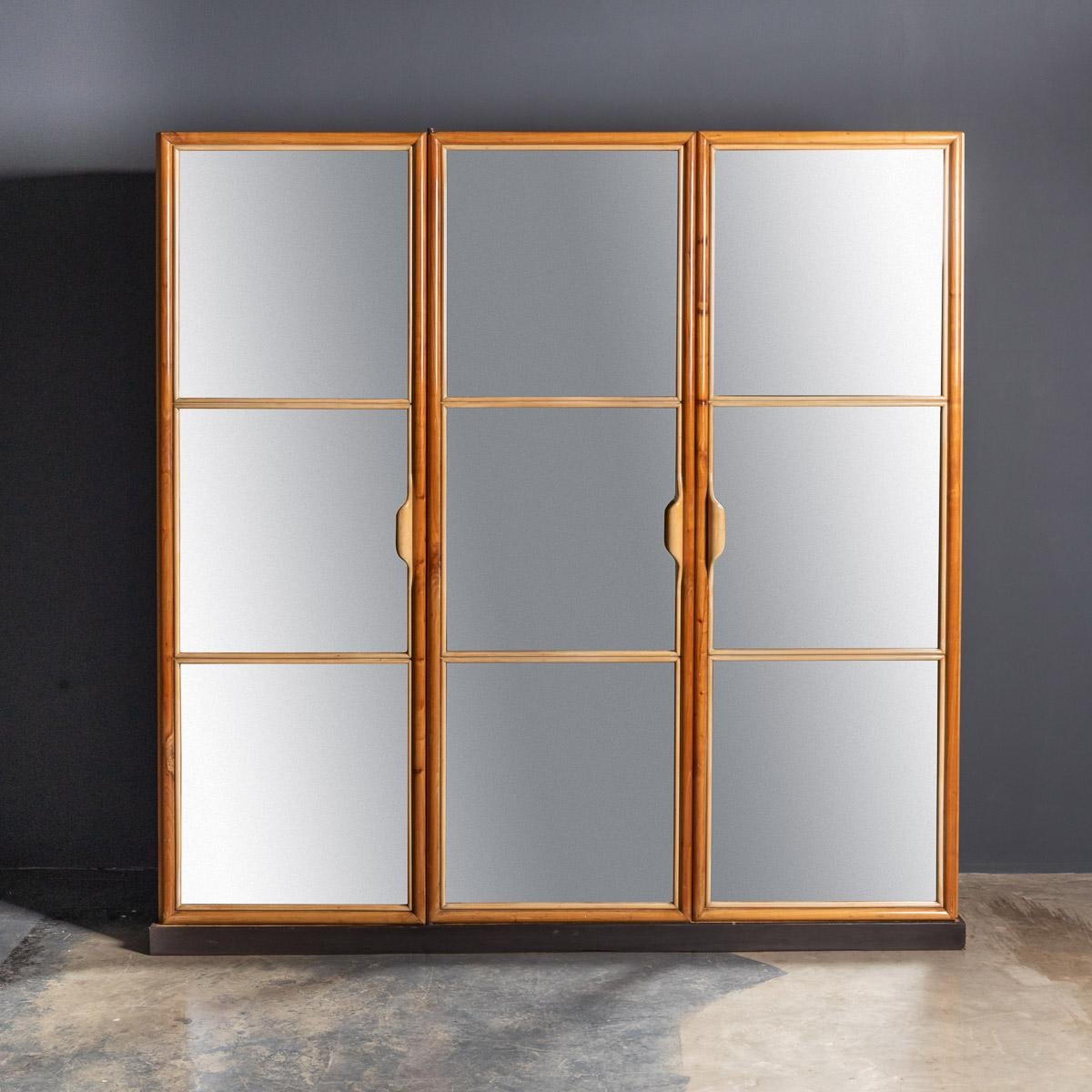 Striking mid-20th century Italian three-door mirrored wardrobe by La Permanente Mobili Cantu, with linenfold detailed sides. On the inside, 4 adjustable shelves, 5 drawers, and hanging space, 2 original keys. Beautiful piece of furniture, looking