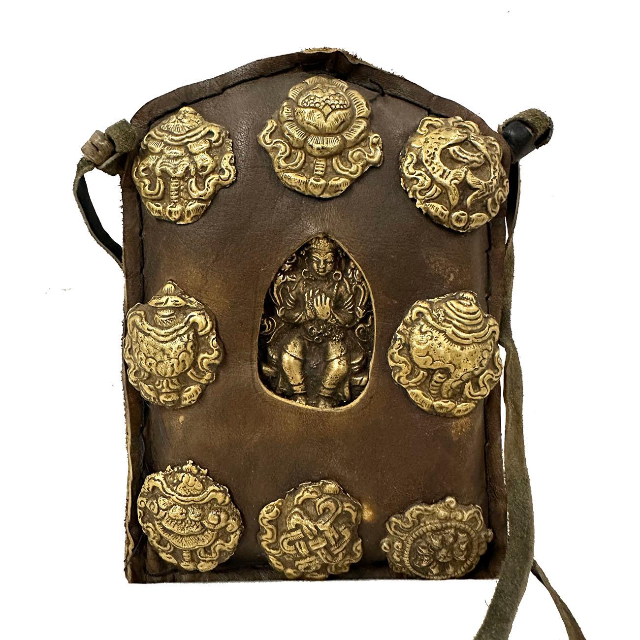  Le ghau est une petite boîte/sac à prières que les bouddhistes portent en pendentif et qui sert de sanctuaire portatif pour prier au cours de leurs déplacements. Ce sac à prières Jewell (châsse de Bouddha de voyage) en cuir est décoré en repoussé