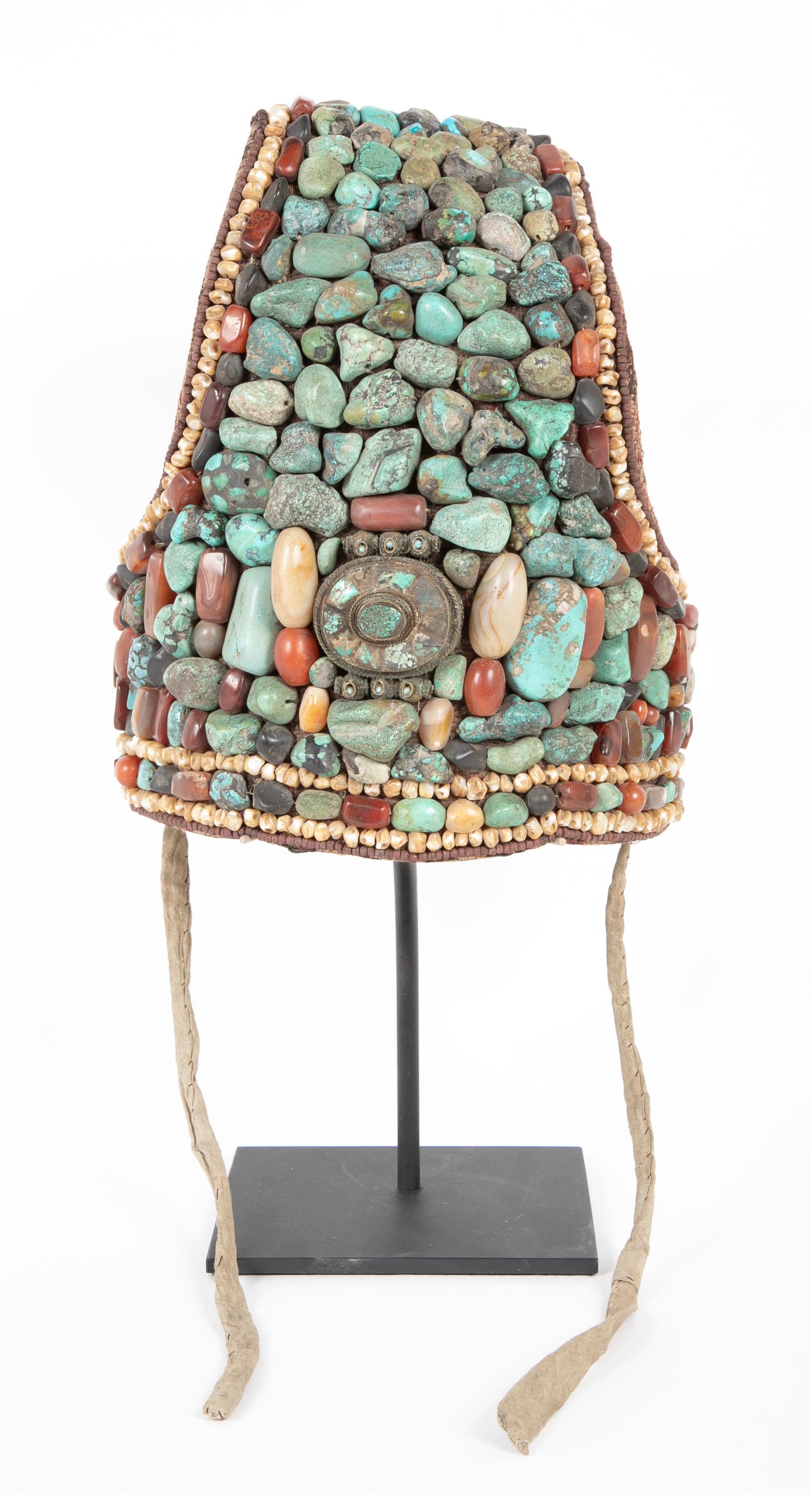 The cobra-hood shaped headdress features a central gahu box surrounded by large beads of turquoise, nacre ( mother-of-pearl ), and other semi-precious materials from Ladakh.  traditionally passed down from mother to daughter, the headdress