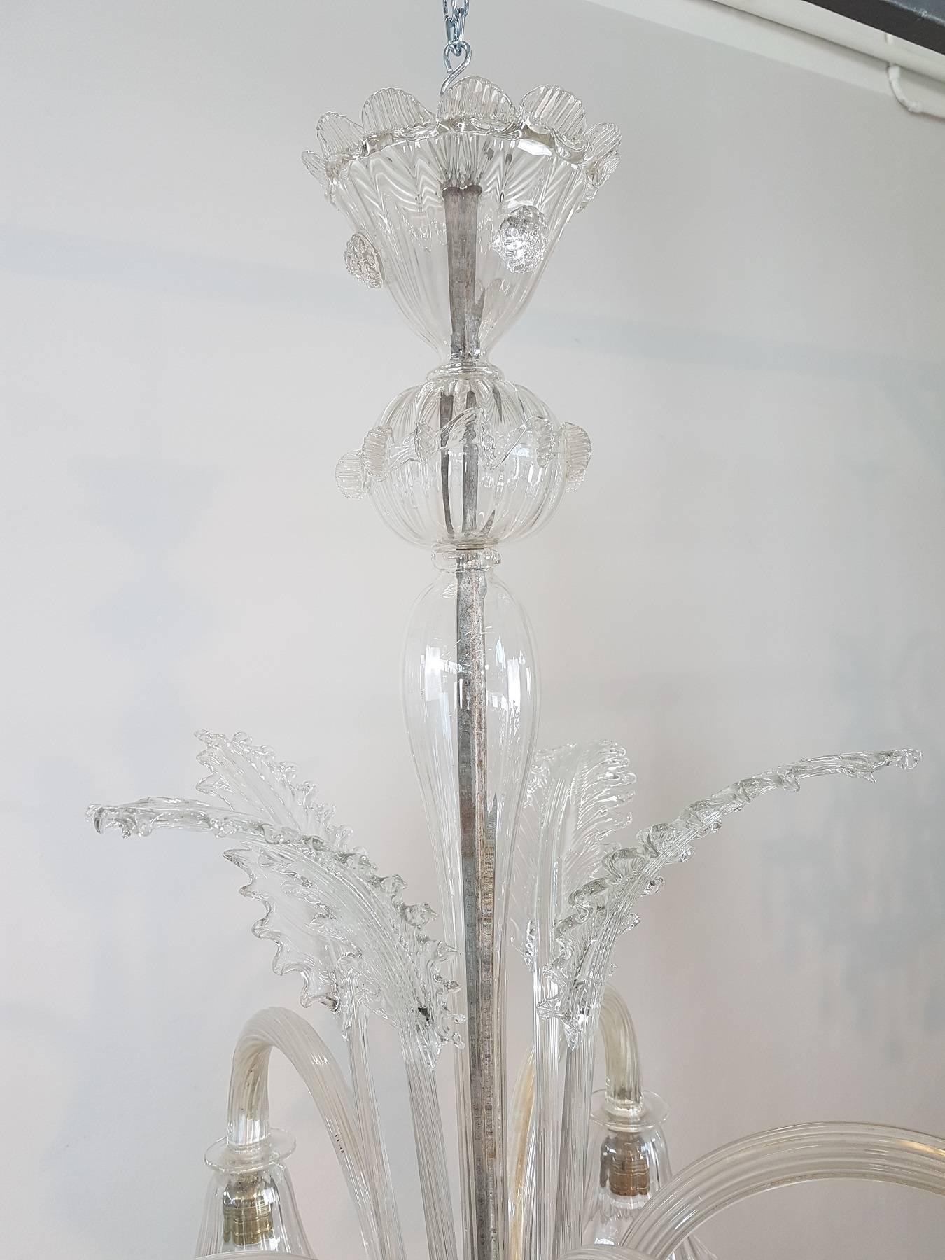 Beautiful and refined artistic glass chandelier of Murano 20th century, circa 1950s total five lights. The chandelier is made with the Classic artistic work of Murano glass in delicate and rare transparent glass.