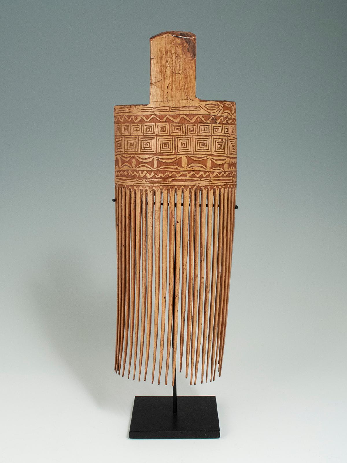 Mid to late 20th century incised bamboo comb, Huon Gulf, Morobe Province, Papua New Guinea

This large incised comb is typical of the bamboo combs of the Huon Gulf area. This particular example is 11.5 inches high and 4.25 inches wide, or 13