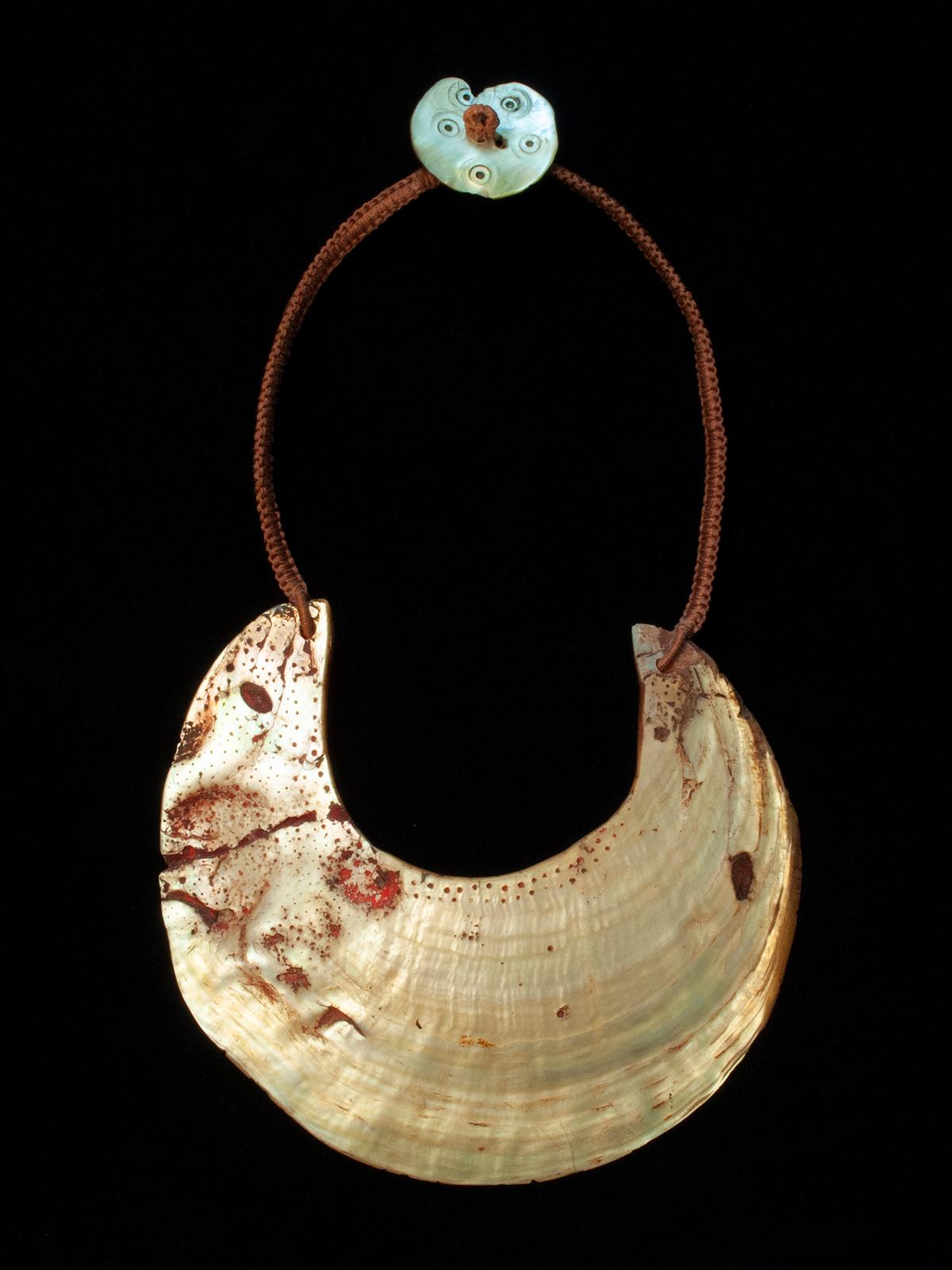 20th Century Tribal Kina Shell Necklace, Papua New Guinea

Kina shells were traditionally worn in the western highlands of Papua New Guinea as pectorals, either with a fiber strap or on a plaque known as a moka kina. This shell has been made into a
