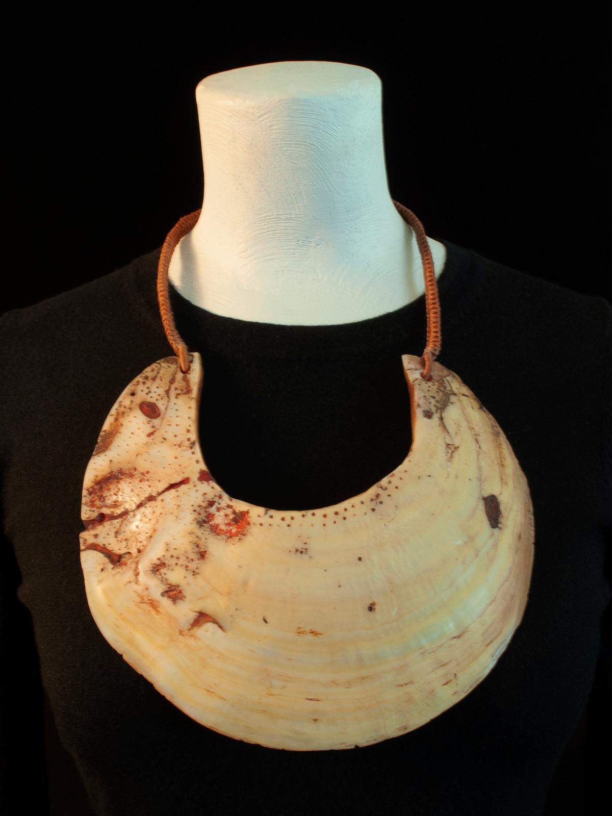 20th Century Tribal Kina Shell Pectoral Necklace by unknown jeweler

Kina shells were traditionally worn in the western highlands of Papua New Guinea as pectorals, either with a fiber strap or on a plaque known as a moka kina. This shell has been