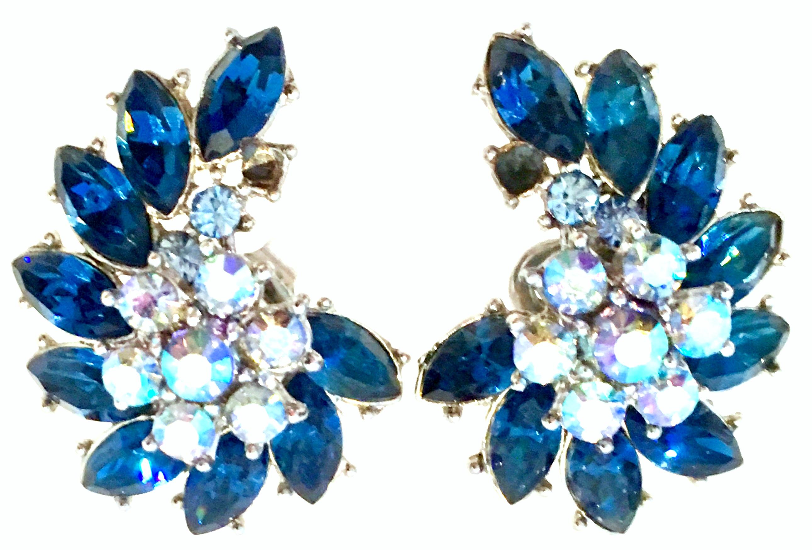 20th Century Trifari Crown Silver & Austrian Crystal Pair Of Earring. These Trifari clip style earrings feature a curved left and right side fit. Set in silver plate with fancy prong set Austrian brilliant cut and faceted crystal stones in sapphire