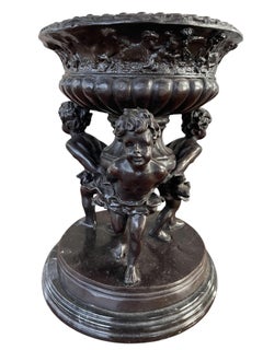 20th Century Trio of Cherubs Urn on marble plinth