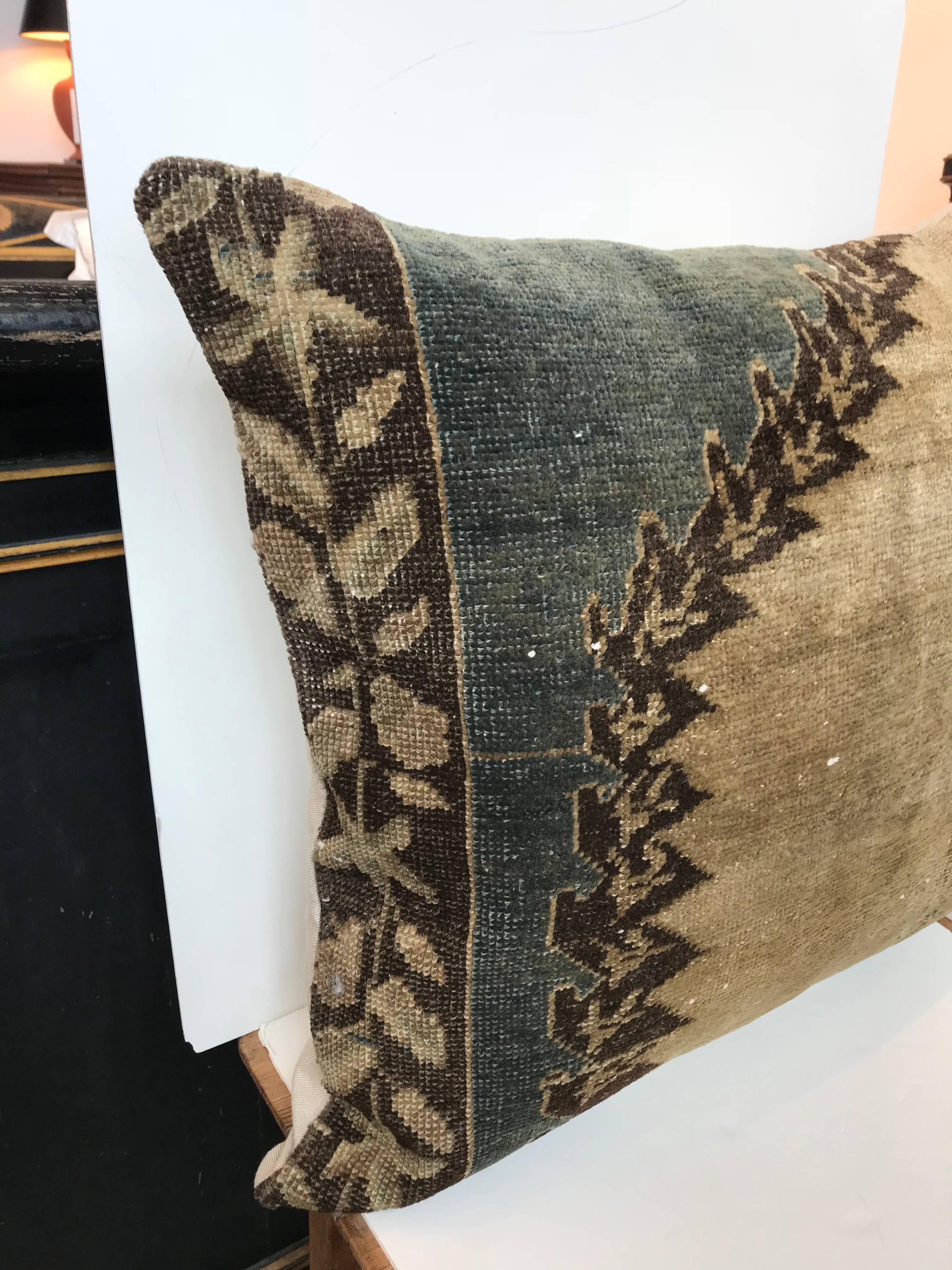 20th century Turkish green and khaki rug pillow; Crafted from a rug fragment. Down insert. Zipper closure with cotton back.