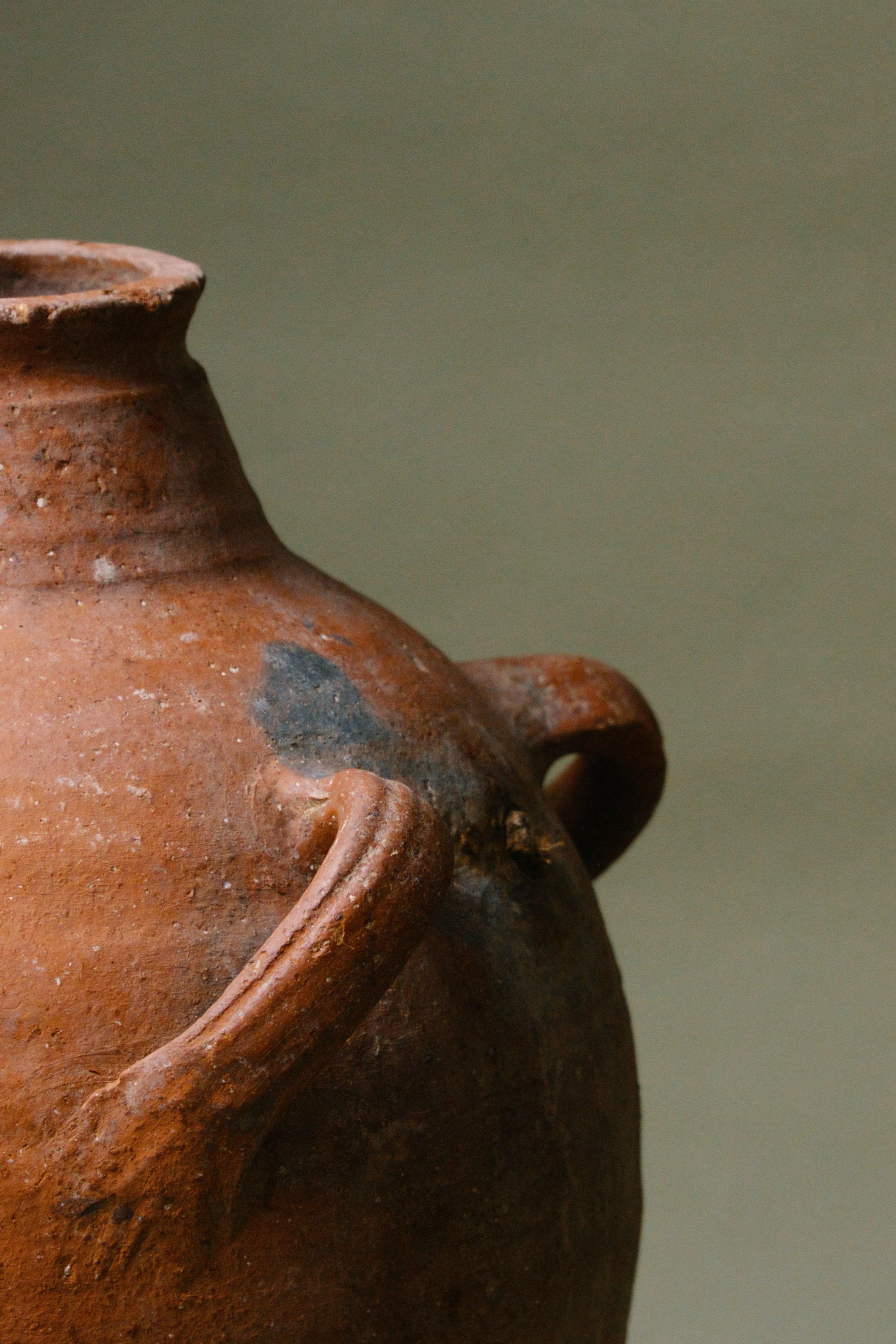 Dieses türkische Terrakottagefäß aus dem 20. Jahrhundert ist ein schönes Beispiel für anatolische Handwerkskunst. Seine glatte Oberfläche aus rotem Ton kontrastiert mit einer natürlich gealterten Patina, die seine geschichtsträchtige Vergangenheit