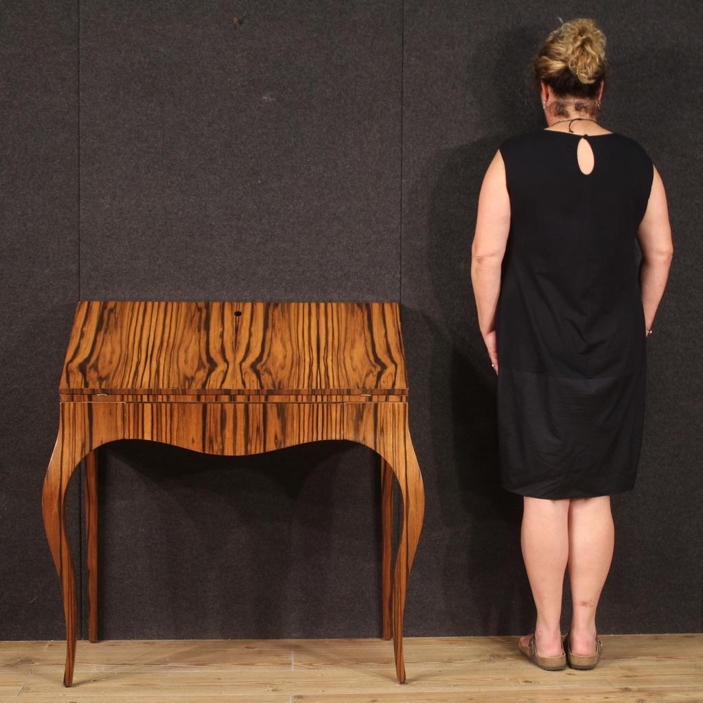 Bureau italien des années 70. Meubles design plaqués en noyer avec un fort impact visuel. Bureau avec pied haut, équipé d'un tiroir extérieur et d'un abattant. Intérieur du meuble complet avec trois tiroirs parallèles, un grand plateau de bureau en