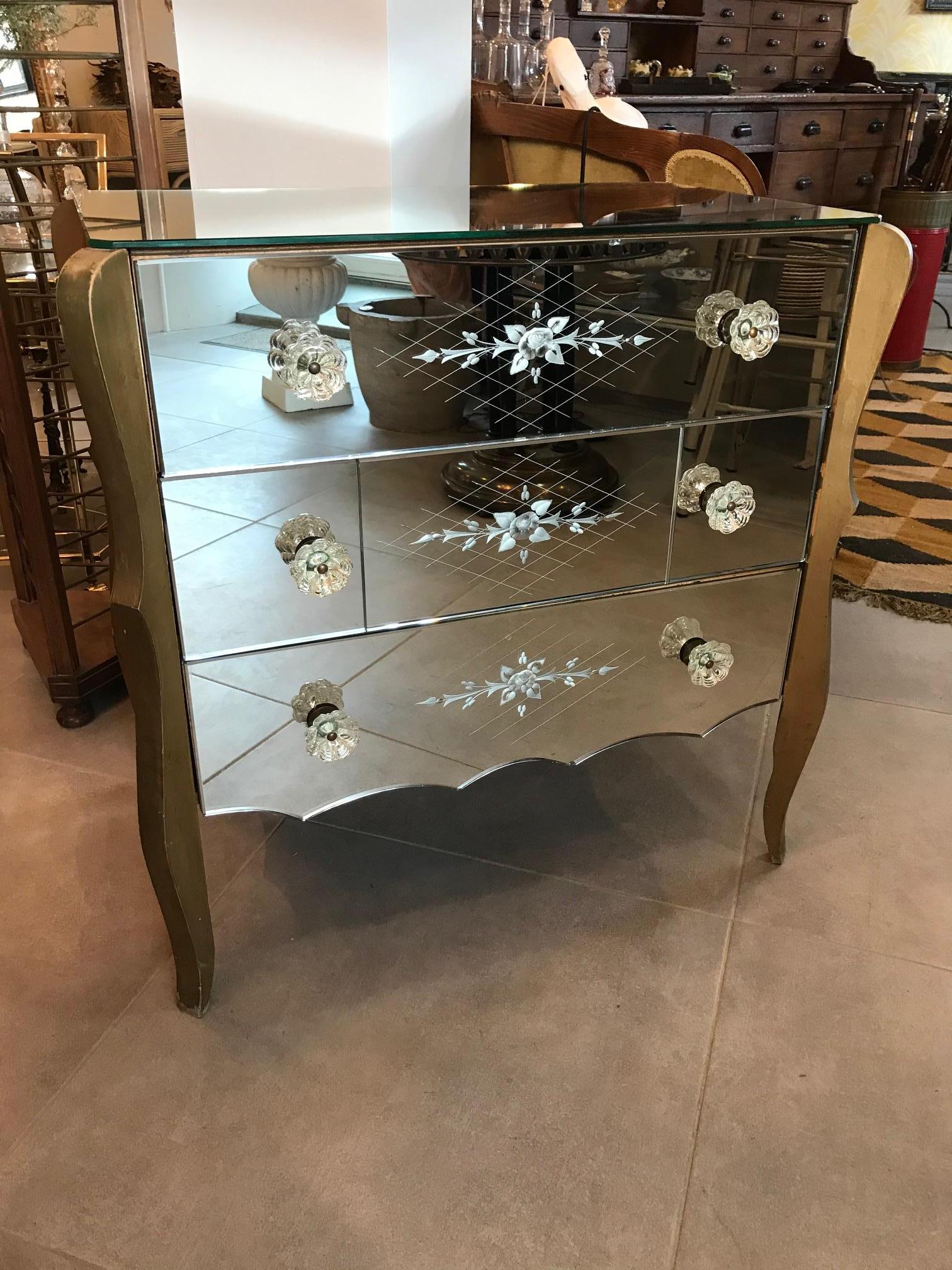Beautiful 20th century Venetian mirror commode from the 1950s.
Three large drawers. The middle drawer has been restored.
Very nice engraved flowers details on each commode sides and on the three drawers.
Glass handles.
Wooden base.