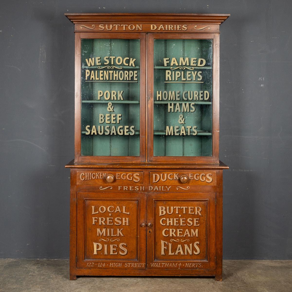 Antique early 20th Century Victorian mahogany grocery store display cabinet, now bearing the charming traces of various food-related advertisements after a later paint job. These pieces, once beautiful examples of period furniture, have been