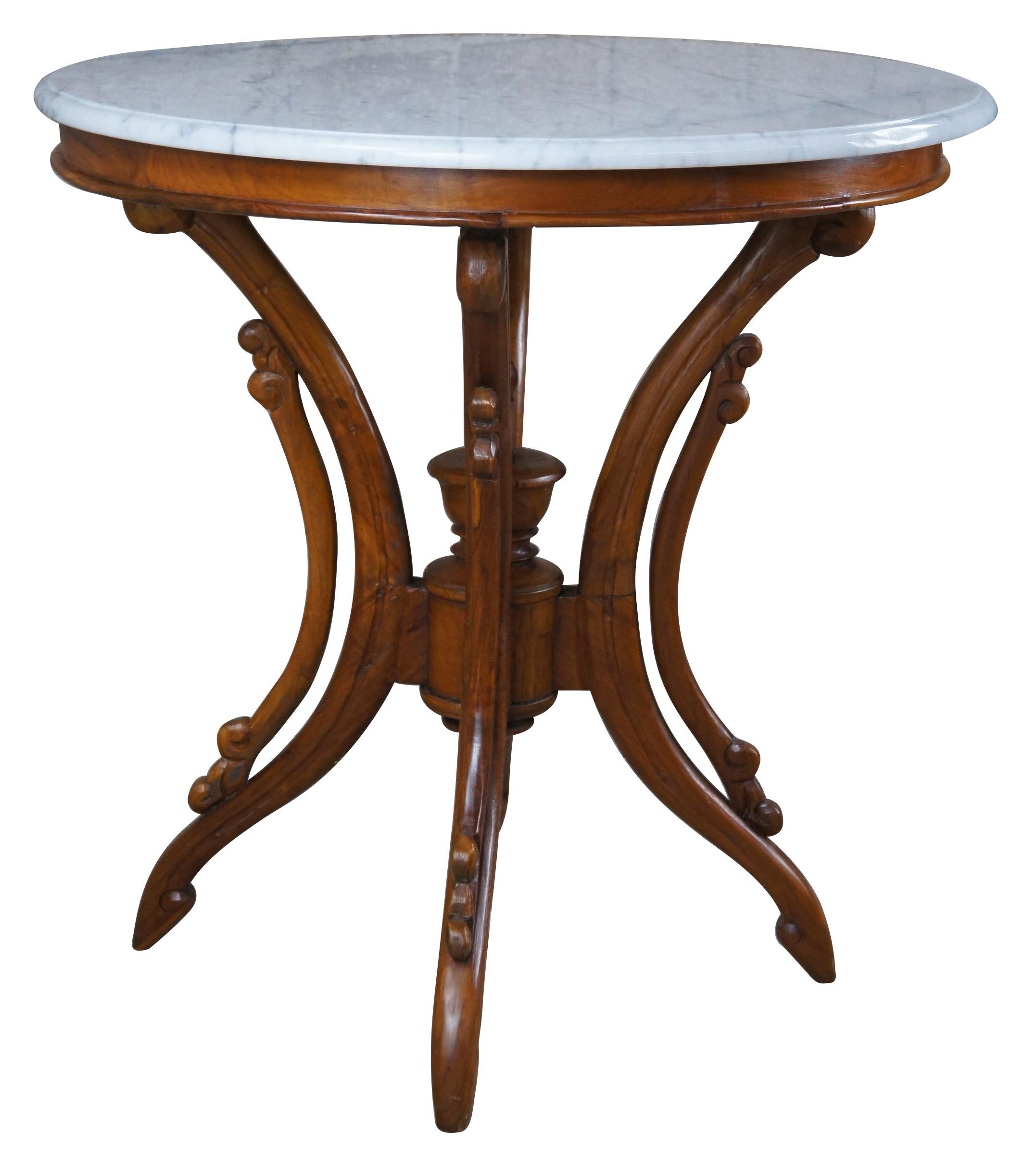 Victorian Revival parlor table. Made from mahogany with long shaped legs, a trophy finial and white marble top.