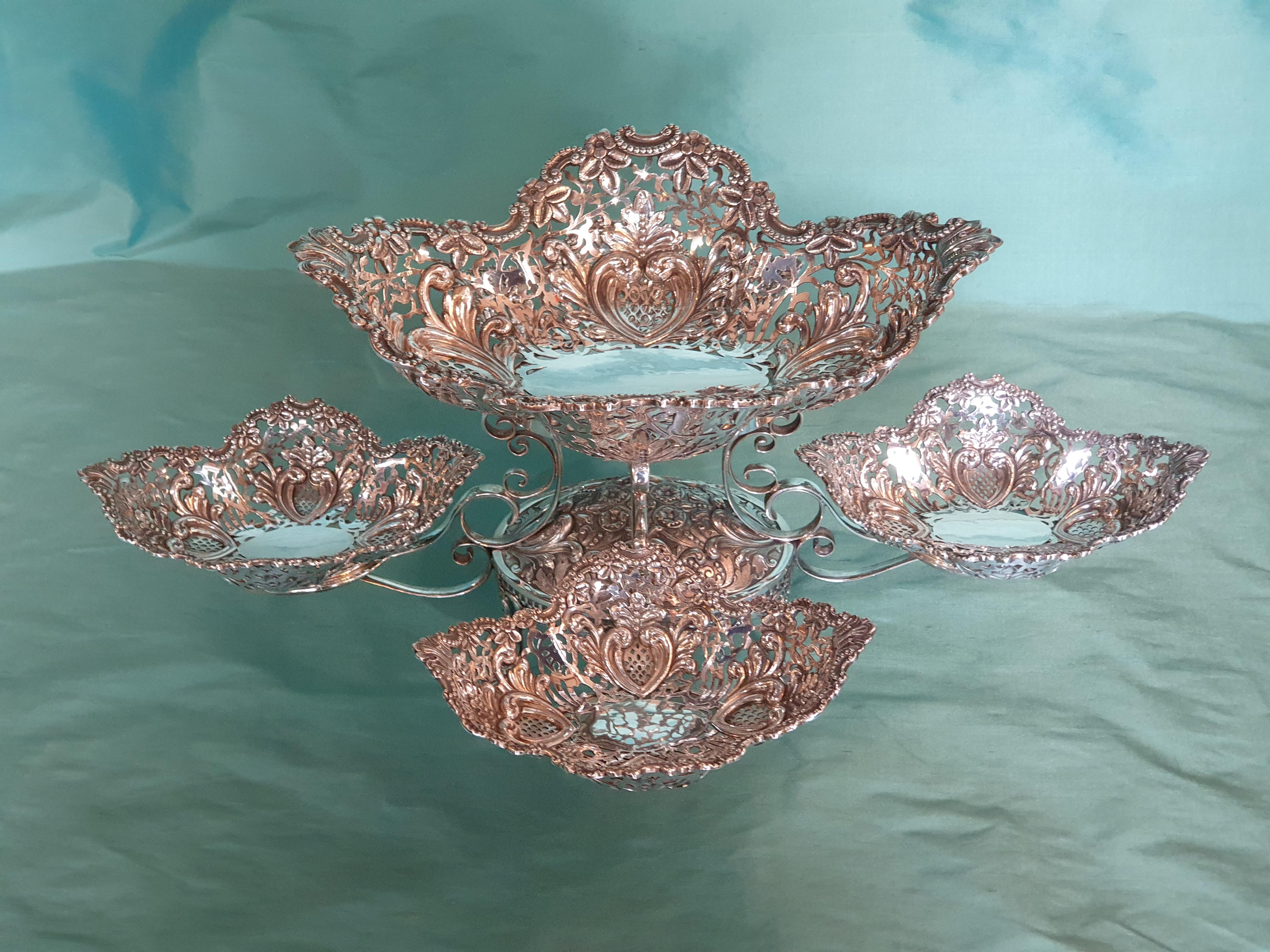 A remarkable Victorian style handcrafted chiseled sterling silver epergne by Italian silversmith Argenteria Auge from Milan. The entire epergne is beautifully embellished with flowers, leaves and hearts.

Epergnes have been a lasting symbol of