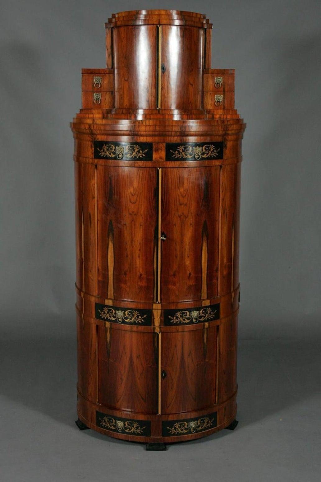 Sensational Vienna secretaire in Biedermeier style.
Tulip veneer on solid pinewood, partially ebonized. Round, bowed body on profiled clump-feet. In the structured front, there are two doors to be found. Fitted with several drawers of different