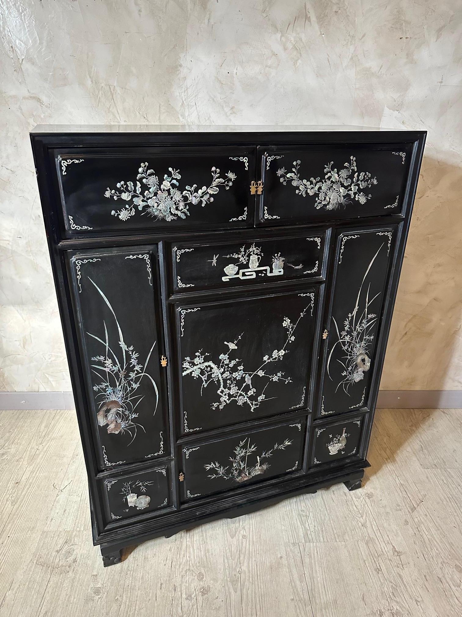 Very nice Vietnamese cupboard dating from the 1950s in lacquered wood and mother-of-pearl inlays decorated with flowers, bamboo, butterflies, vases...
Several opening doors. Some imperfections but good general condition.
Manufacturer's labels inside.
