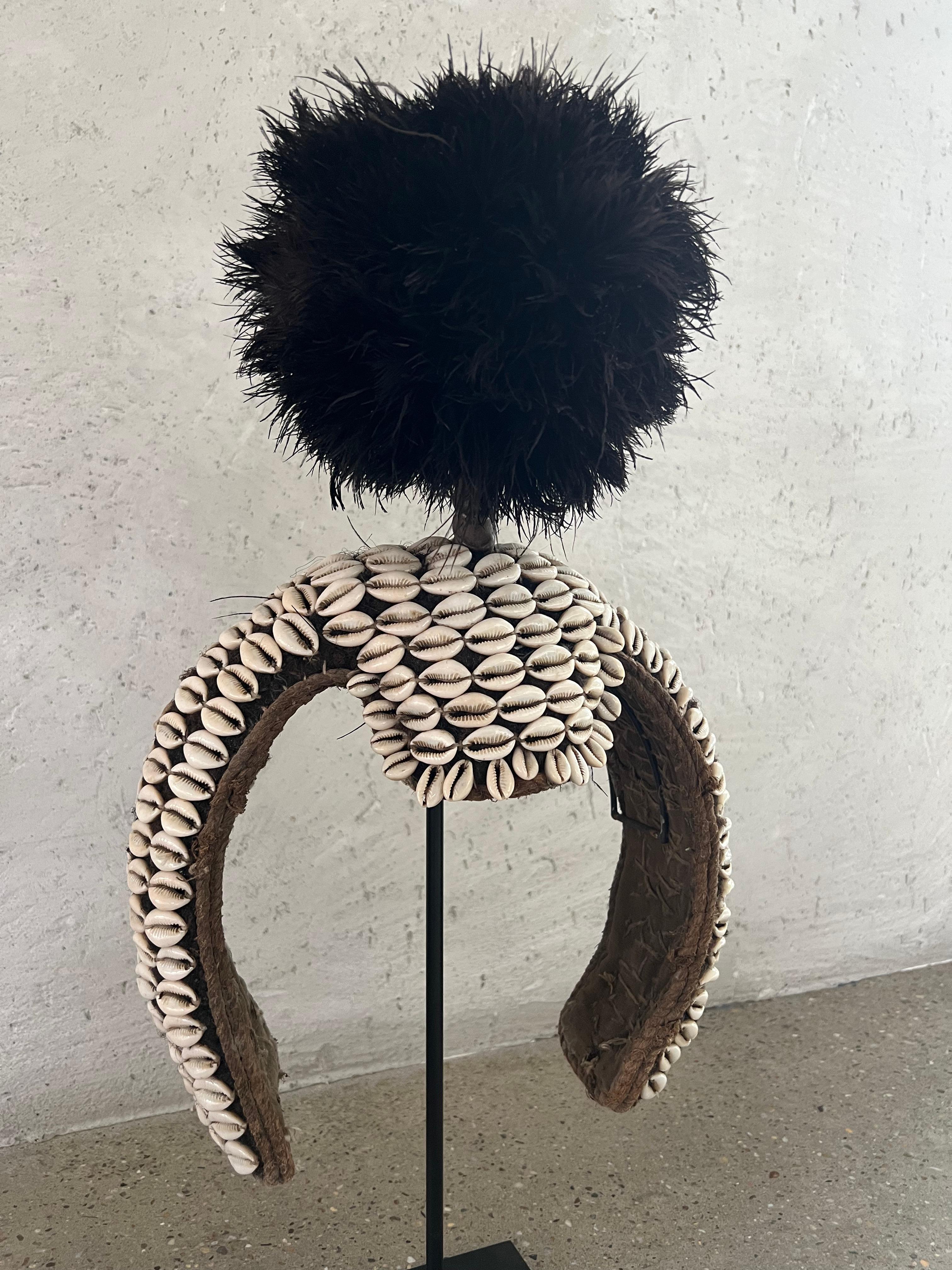 Bamileke headdress, originating from the Bamileke ethnic group in Cameroon, is ceremonial and symbolic artifacts used in traditional ceremonies and rituals. It is crafted using natural materials, feathers, shells, and beads.

The headdress itself is