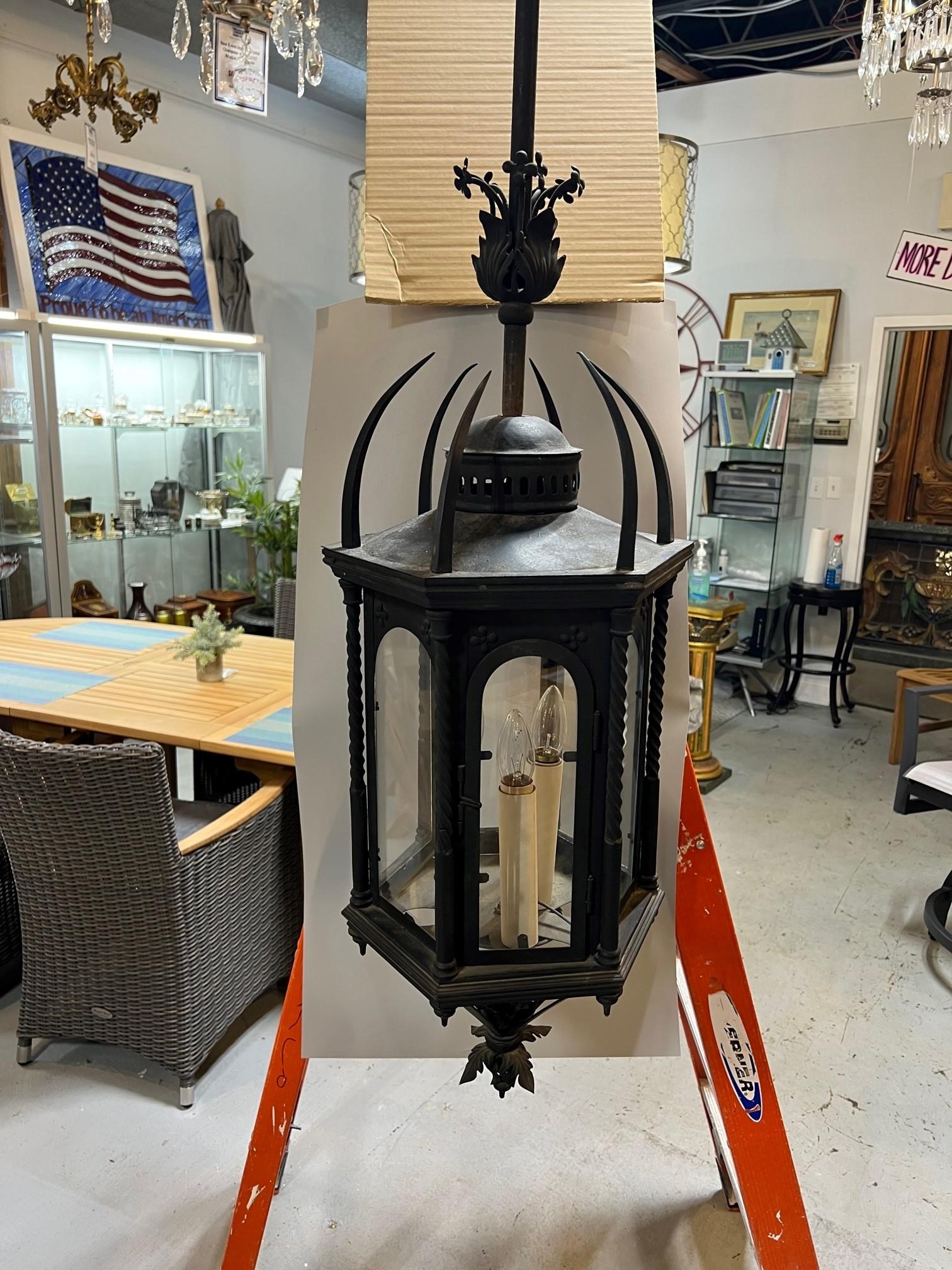 Vintage black iron lantern chandelier with six arched glass panels one a hinged door. This is a nice lantern with twisted columns and spikes or spears on the top. Salvaged from an estate in Stamford Ct where it hung outside on the front porch. It is