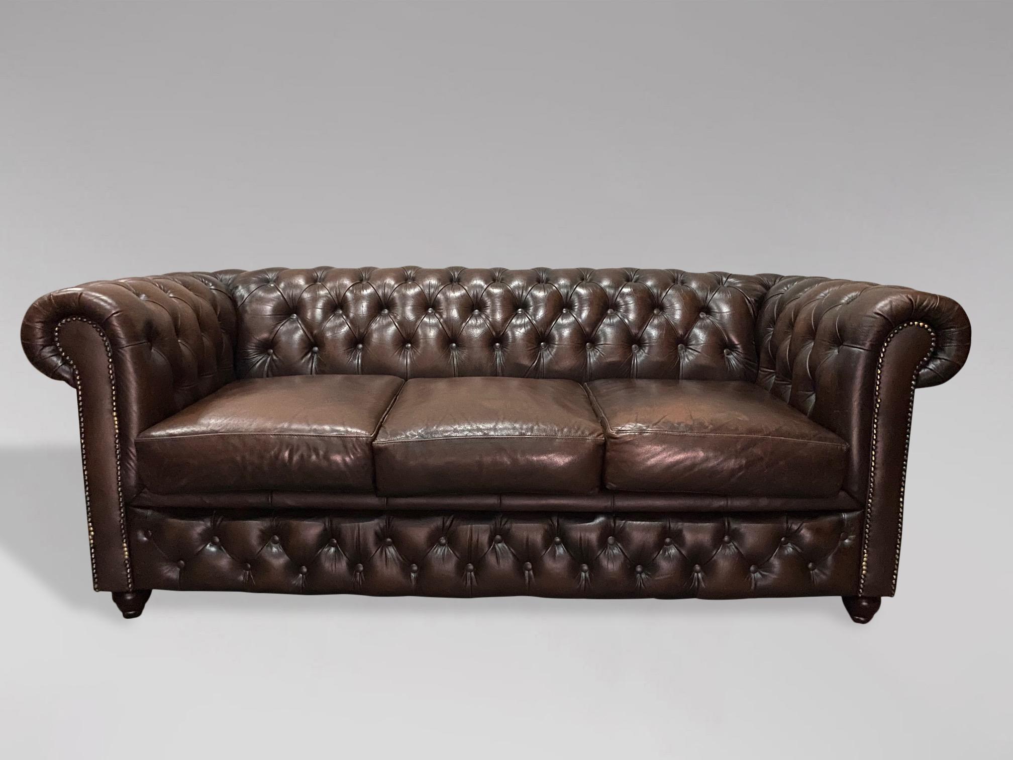 A 20th century large three seater vintage brown leather chesterfield with three large loose cushions, raised on 4 bun feet. A fine example of a good quality comfortable chesterfield. Very comfortable seating. A rather pleasing example.

The