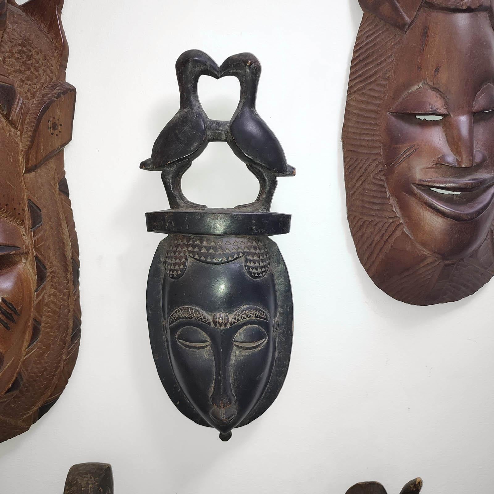 Masque mural en bois sculpté à la main, vintage du 20ème siècle. Art populaire africain. 
Fabriqué à la main et sculpté dans une seule pièce de bois exotique, d'une manière propre à l'art traditionnel africain. Sculpté à la main avec le visage