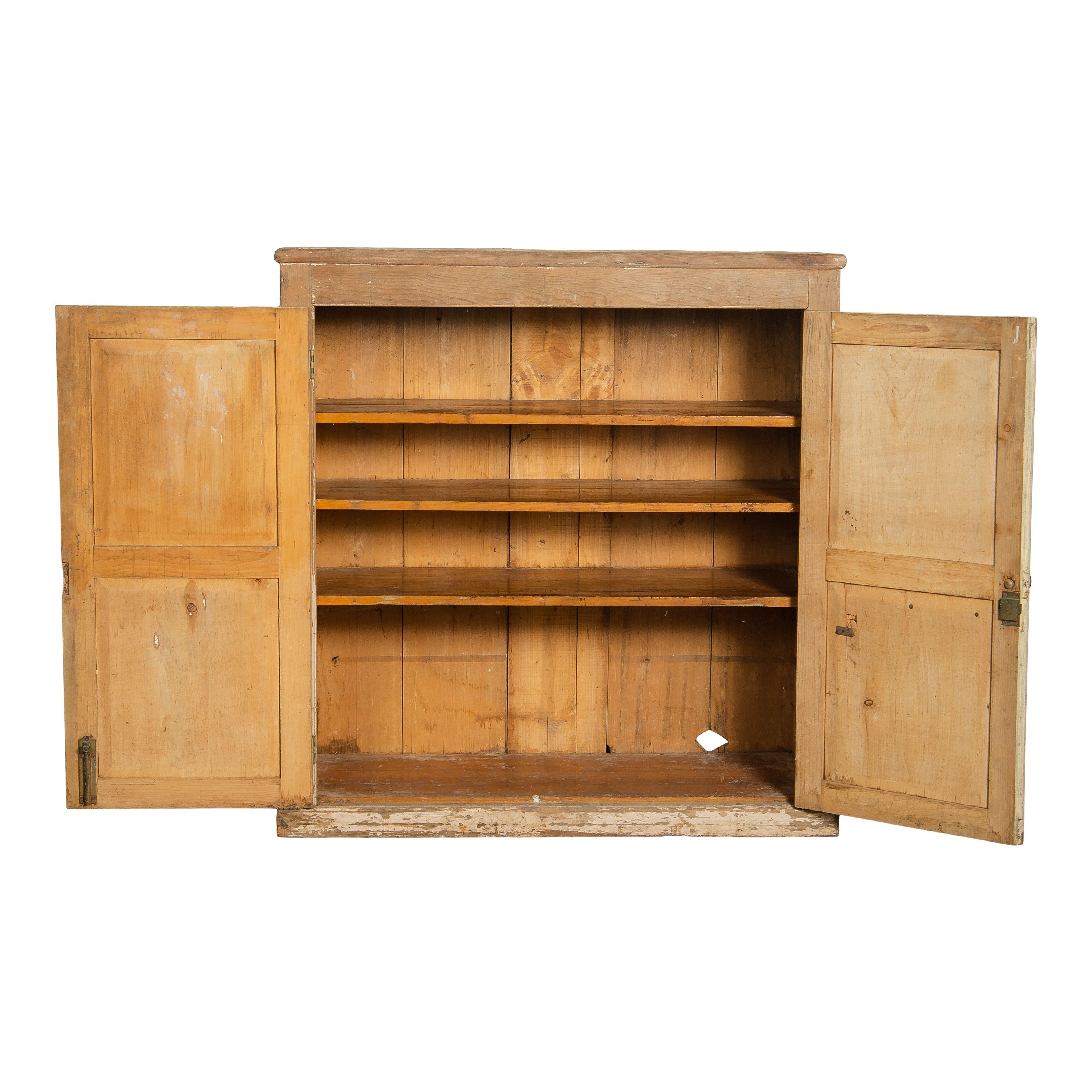 Un armadio vintage in legno con ripiani proveniente dall'Europa. La credenza presenta una vernice scheggiata sulla metà inferiore, che le conferisce la perfetta patina vintage dovuta agli anni di utilizzo. Il design semplice è caratterizzato da due