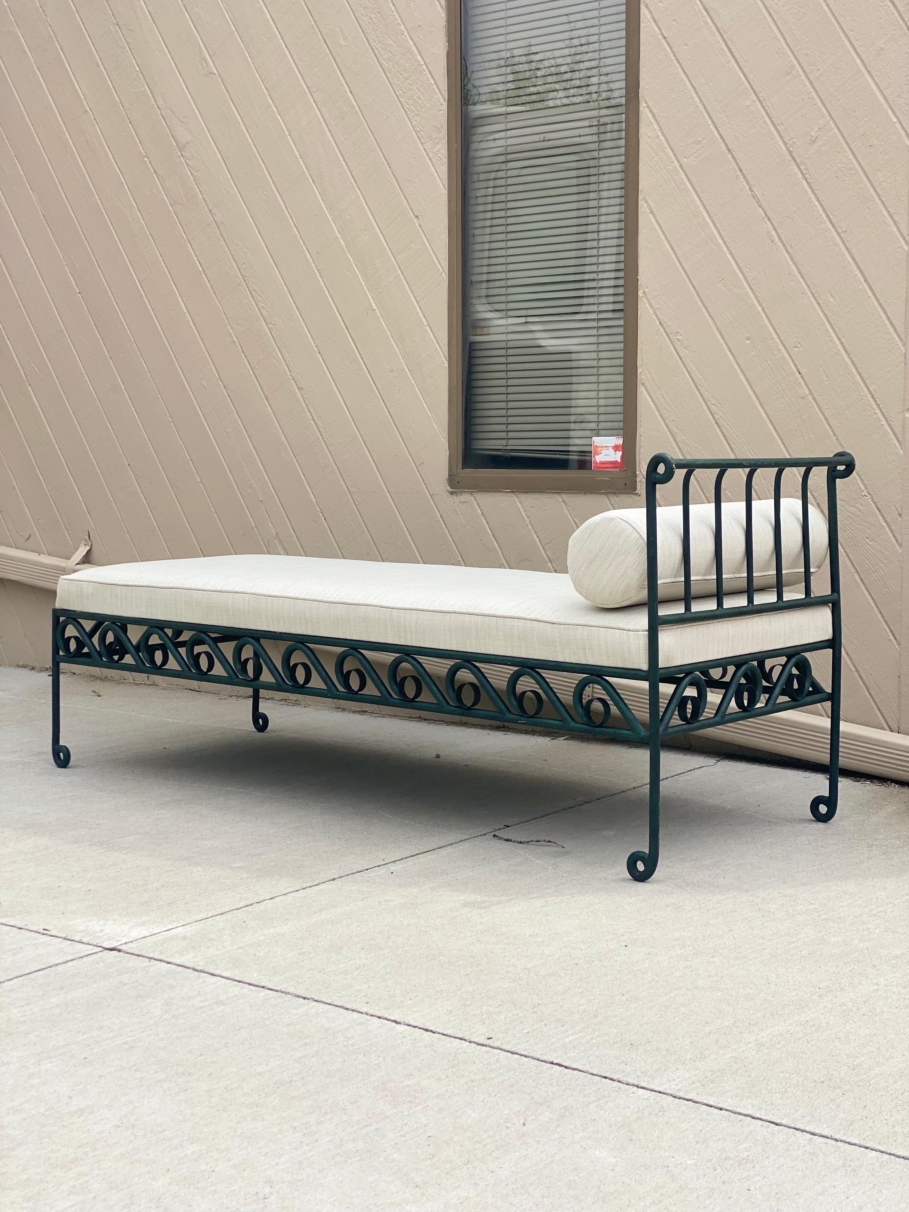 We are very pleased to offer a vintage French daybed, circa the early 20th century. This piece features a low platform and is constructed from solid metal with a powder-coated dark green, matte finish. The frame showcases a Classic swirling pattern