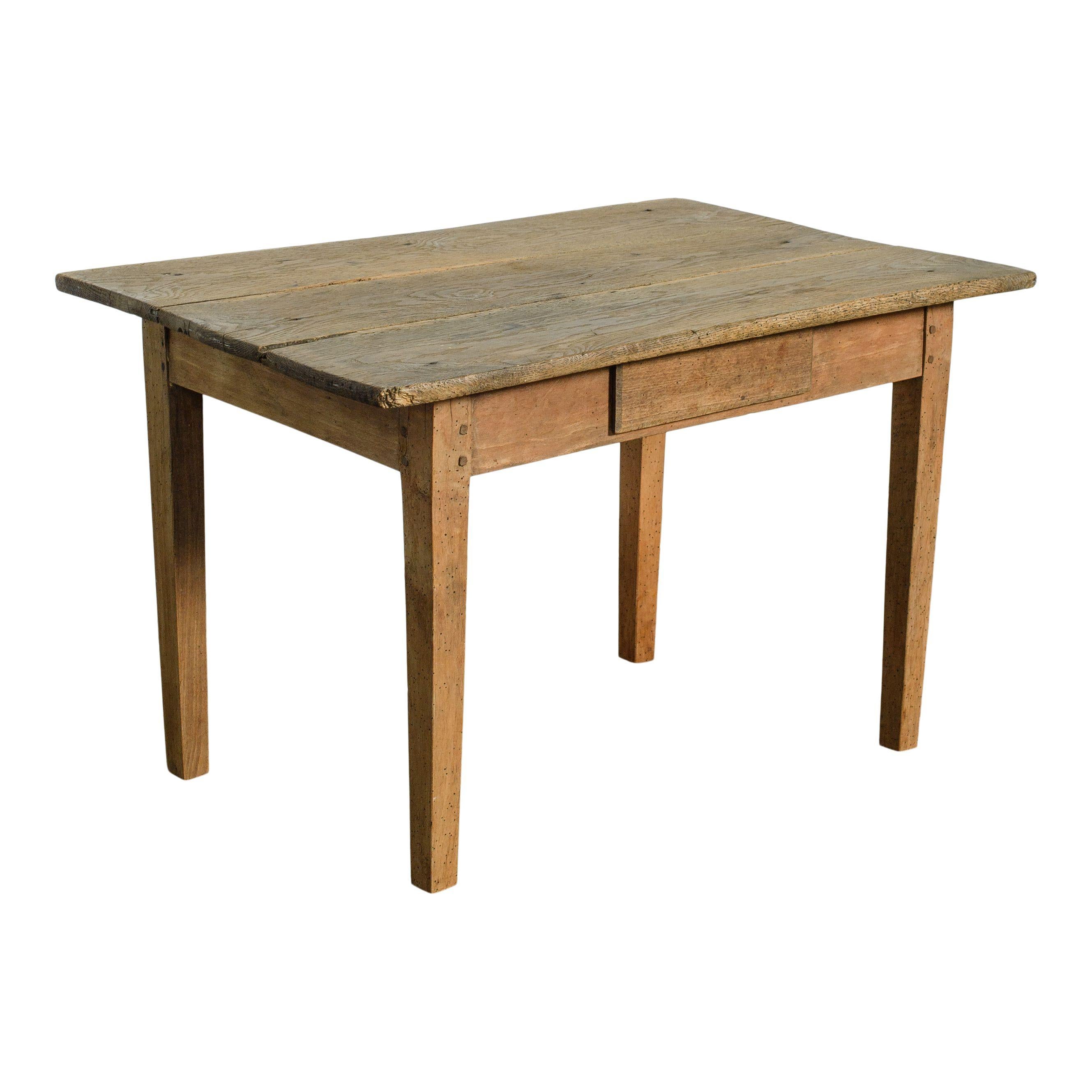 Petite table en bois avec un petit tiroir, originaire de France. Le plateau de la table est un bois naturel usé qui dégage une chaleur simple et intemporelle. Le petit tiroir est le parfait petit complément de rangement. Avec de simples pieds en