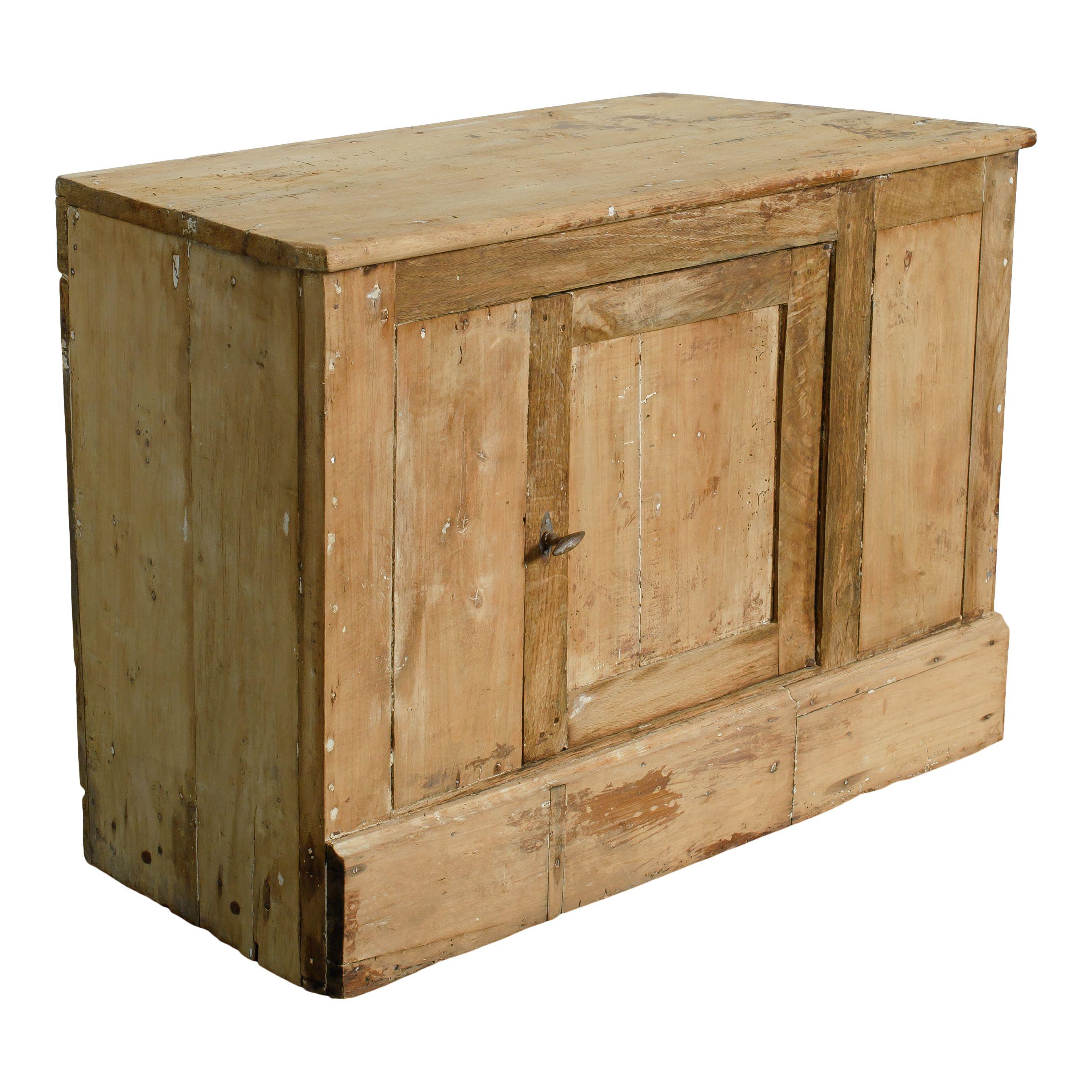Un pequeño y perfecto armario vintage de madera procedente de Francia. El sencillo diseño de este armario es encantador y atemporal, con un acabado de madera en bruto y una pequeña puerta con estantes en el centro. Los laterales del armario están
