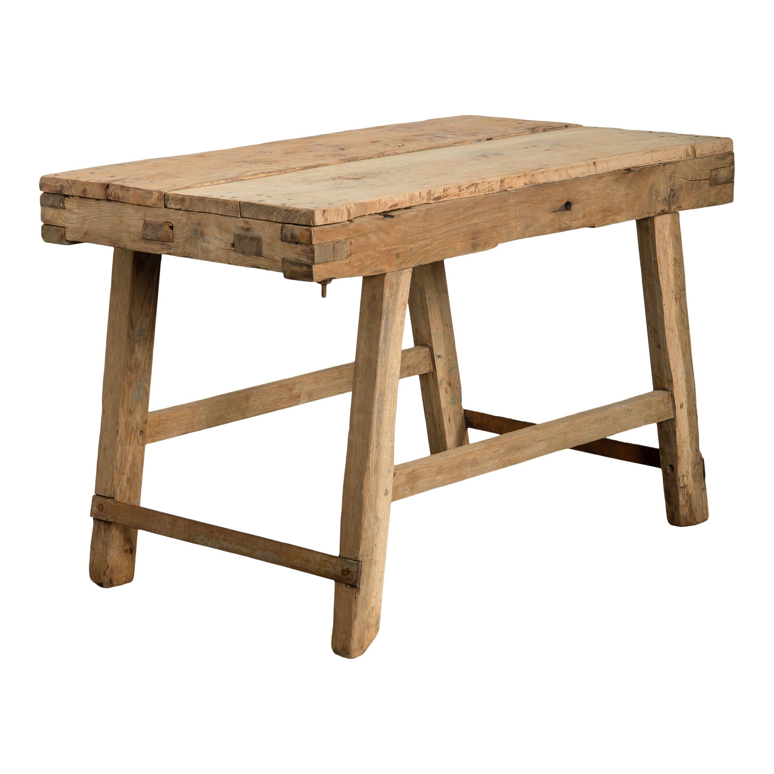 Une table vintage en bois brut provenant de France et fabriquée au 20ème siècle. Le design simple de cette table, du plateau rectangle en bois brut aux simples pieds inclinés et aux traverses, en font une pièce intemporelle et classique. Cette table