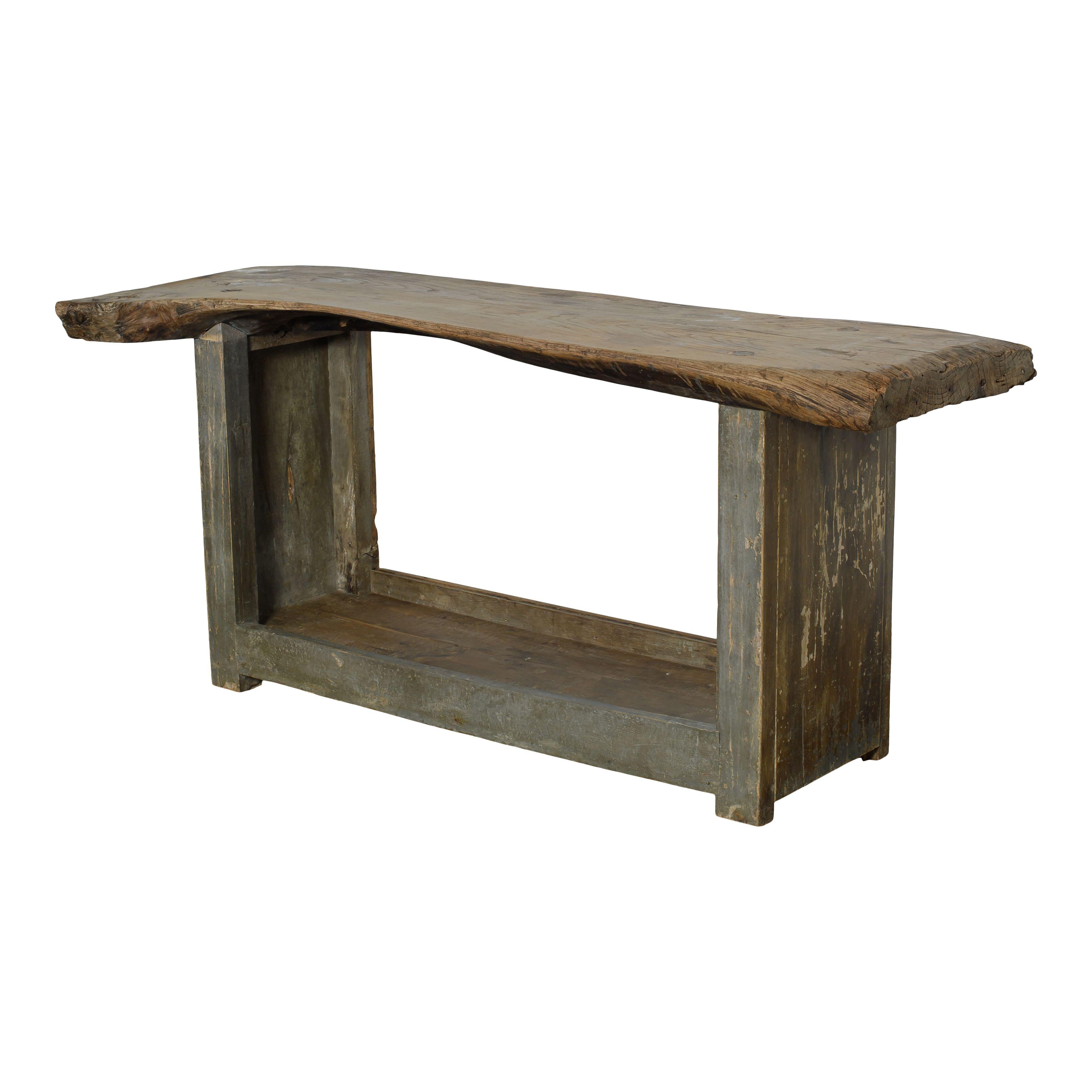 Vintage wood console table from France. The top is a lovely raw piece of wood with an organic shape and the perfect vintage patina. The legs are blueish grey and they meet at the bottom to form a shelf. The simplicity of the design makes this a