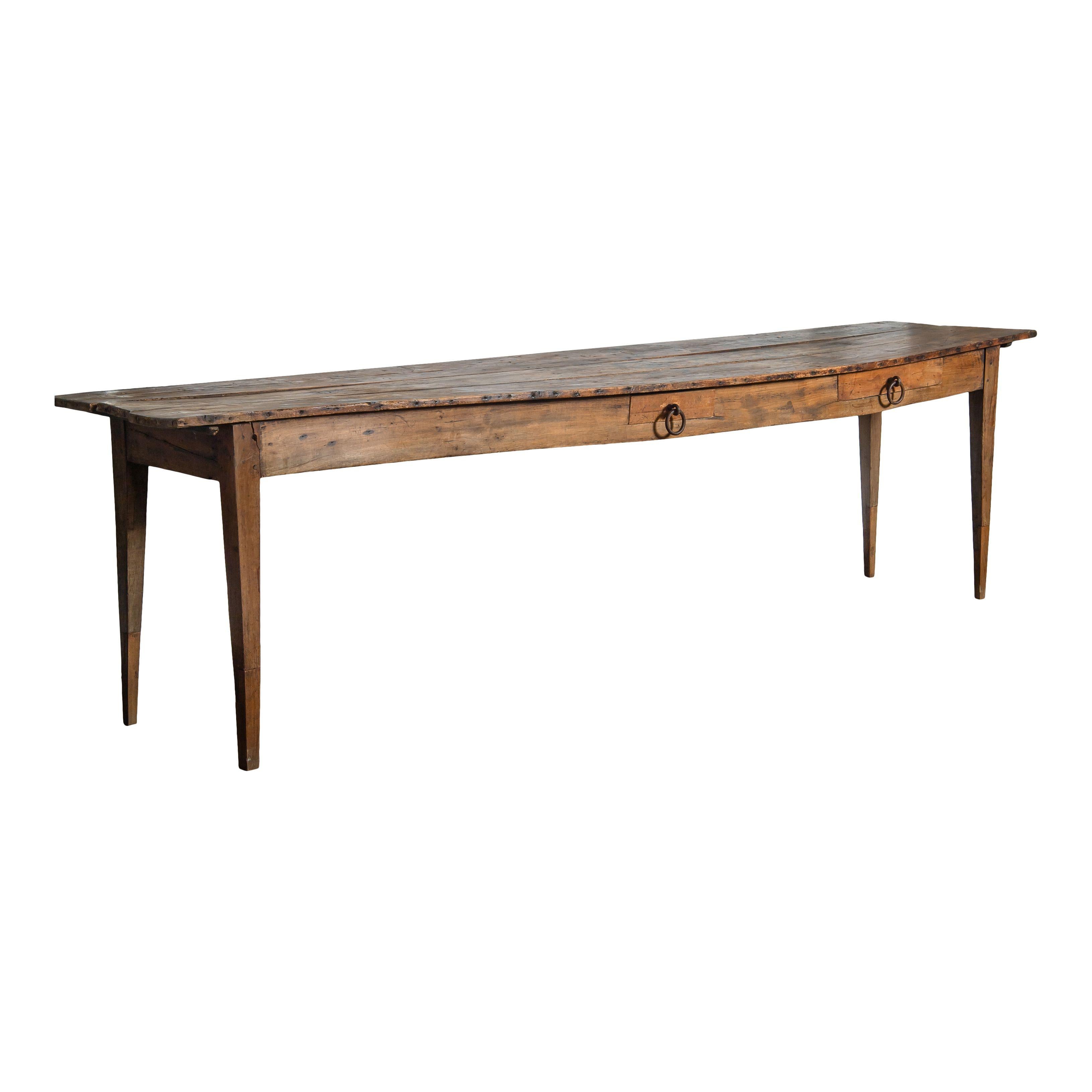 A large vintage wood table from France. The table is simple with four straight legs and a thin wood top -- a classic and timeless design. There are two small drawers with metal ring pulls. Perfect for any dining area or home and sure to add vintage