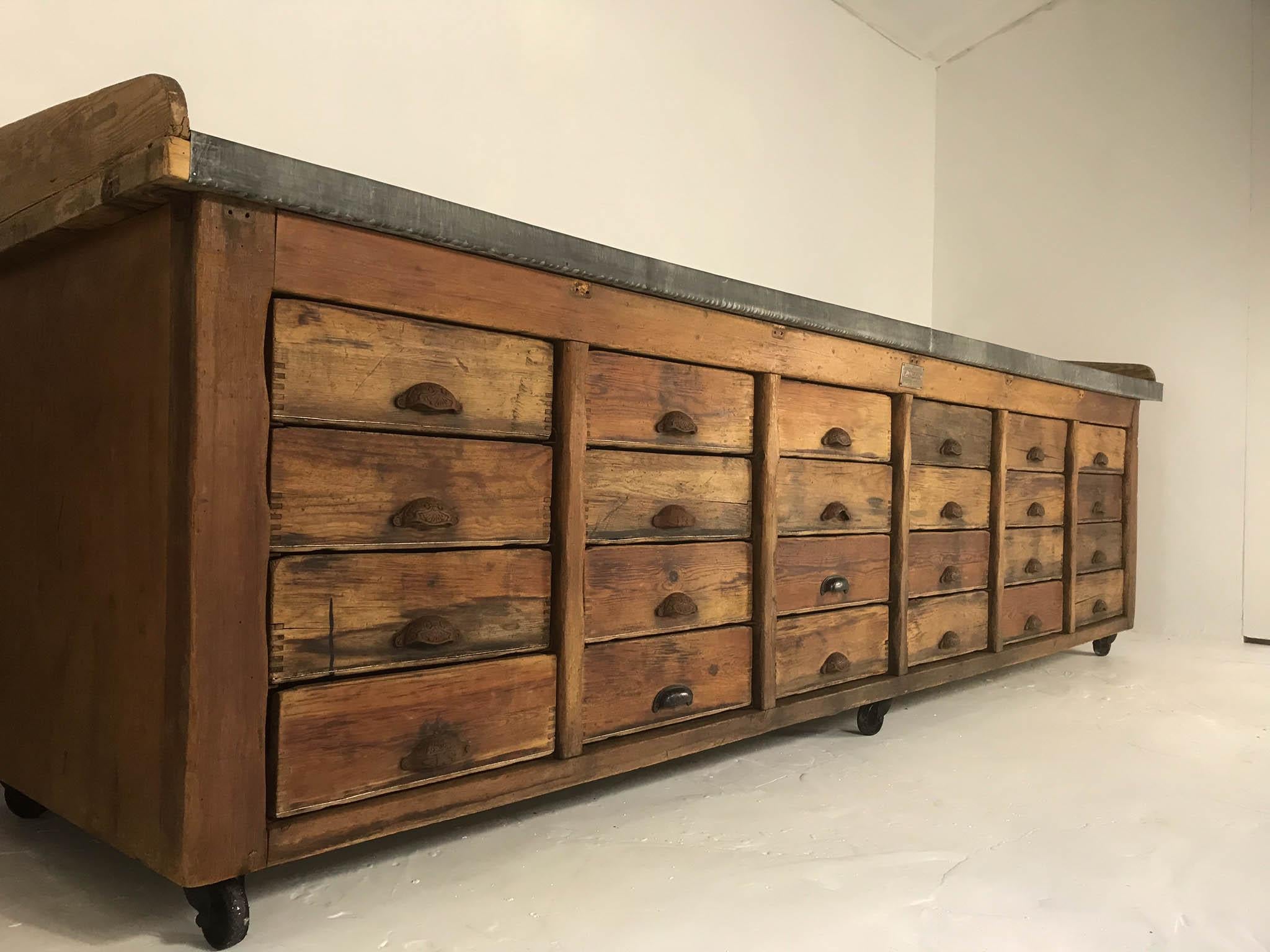 Huge pine table rescued from a bakery in Newcastle, England. Manufactured in the 1940s by Terrington & Sons, Portsmouth the renowned makers of bakery products. Features 24 drawers with cast iron handles, aged zinc top and castors.
A truly unique