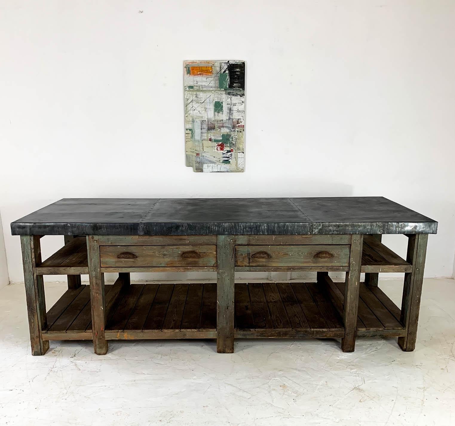 Fantastic, fully restored carpenter's workbench from the North of England. We have added a beautifully aged zinc top, which resembles grey slate in colour, to the greenish pine and oak base. Zinc is a very practical and hygienic material to use in