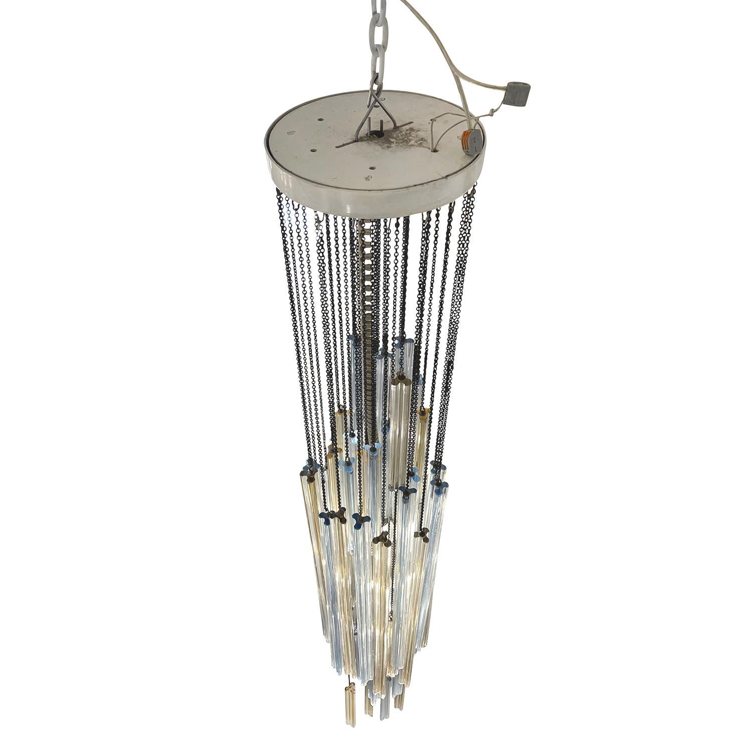 A vintage Mid-Century modern Italian pendant, chandelier made of hand blown smoked Murano glass designed by Paolo Venini, in good condition. Each glass piece, element of the ceiling light is hanging from a fine brass chain, halted by a small, round