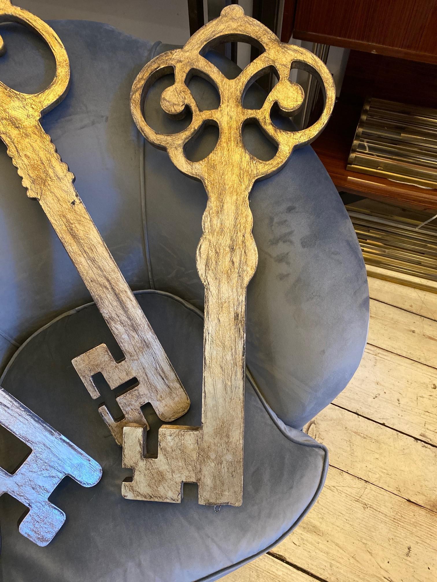 Set of three 20th century vintage decoration keys in silvered wood.