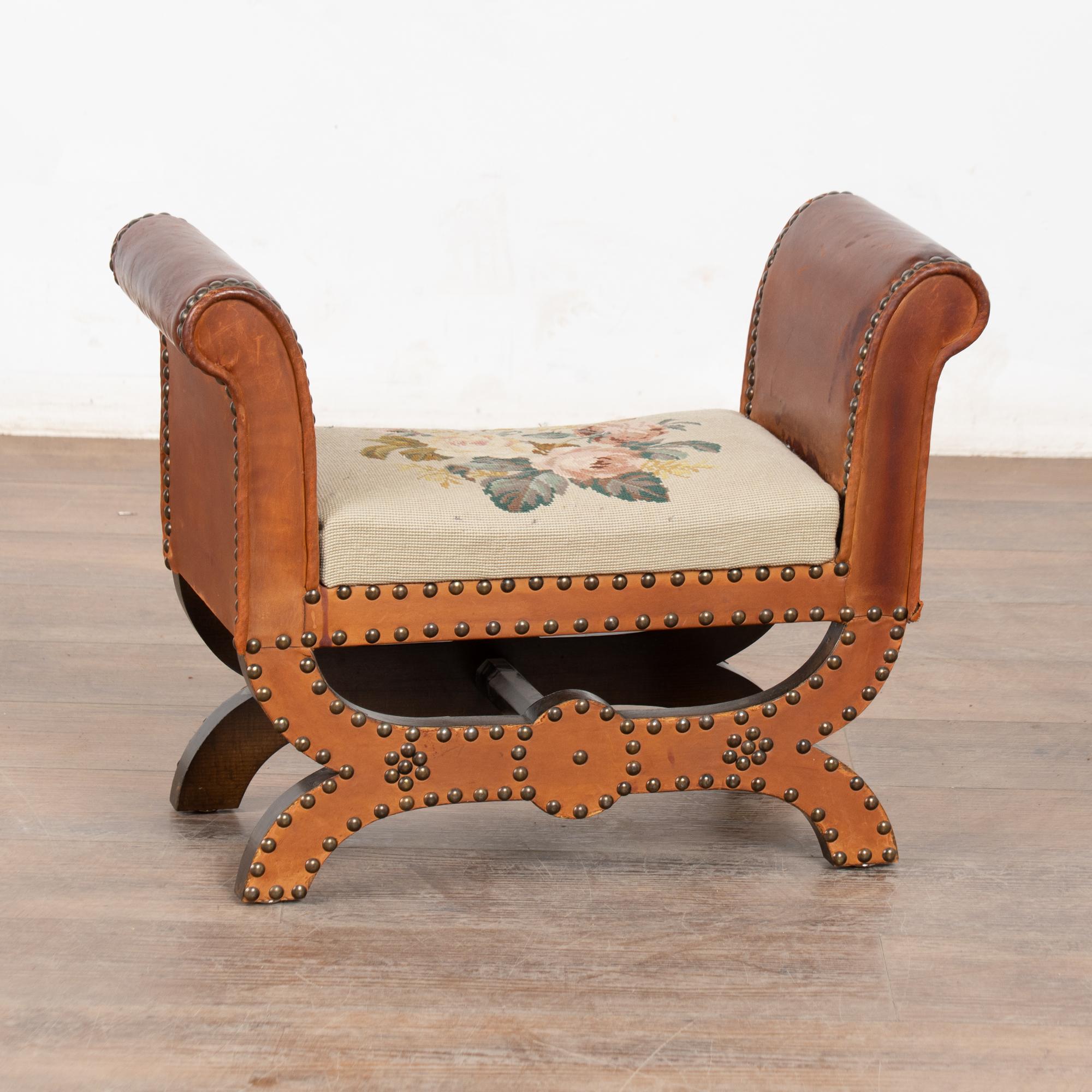 Tabouret vintage du 20e siècle avec structure en bois, cuir vieilli et garniture en tête de clou, et assise en aiguille vintage.
La patine profonde du cuir et son usure subtile ajoutent à son attrait.
Des taches visibles, des éraflures, des