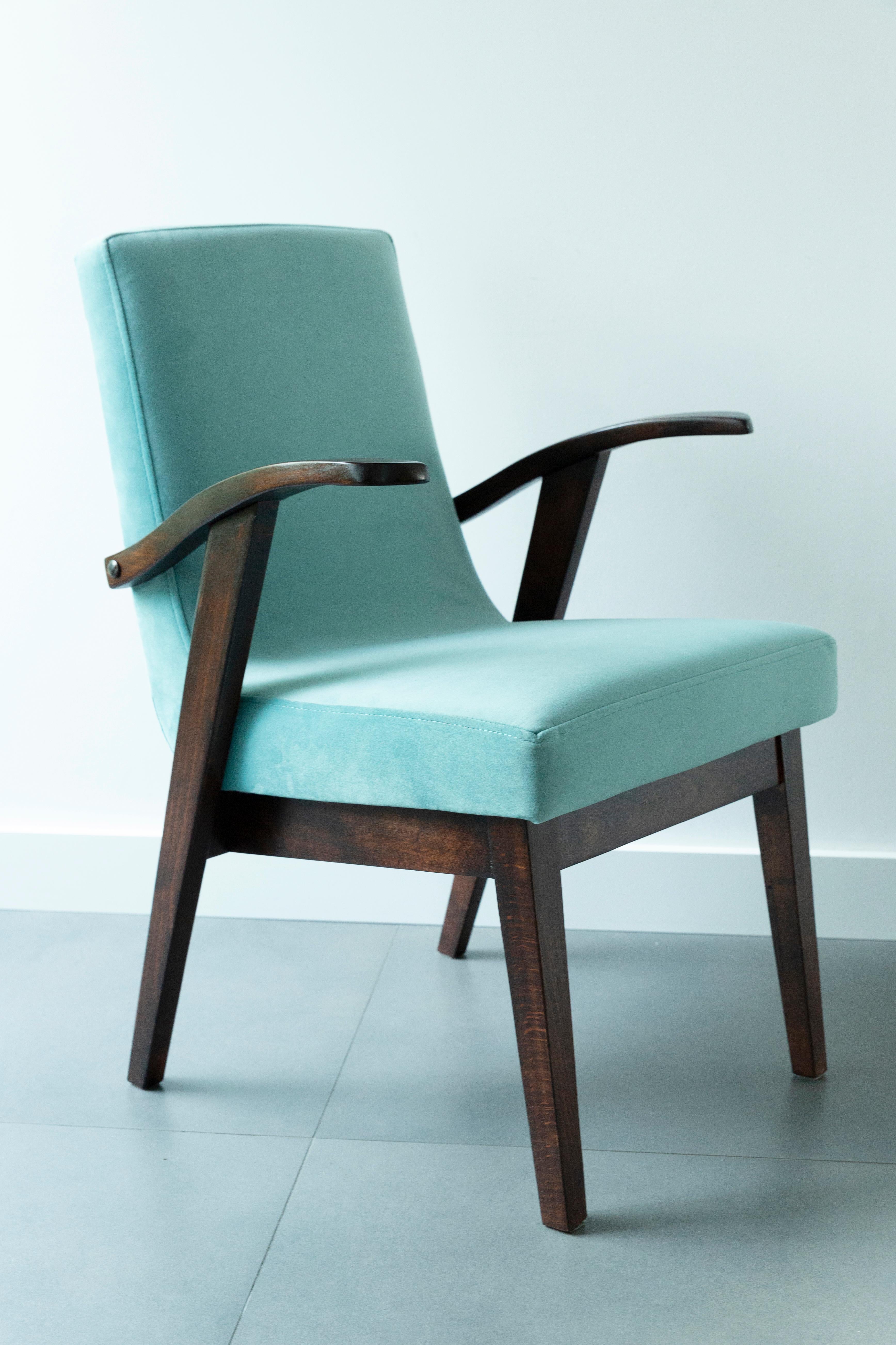 Armchair designed by Mieczyslaw Puchala. Dark brown wood combined with a mint green beautiful velvet gives it elegance and nobility. The chair has undergone a full carpentry and upholstery renovation. The wood is in excellent condition after full