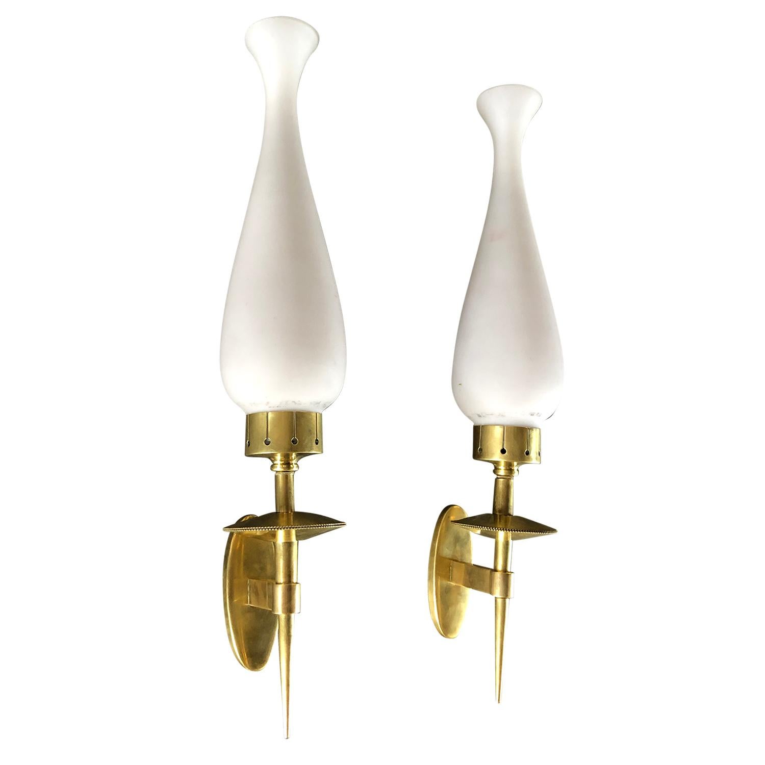 A vintage Mid-Century Modern Italian pair of wall sconces made of handcrafted brass, enhanced by very detailed decoration with two frosted opal glass shades, imitating a tulip, each is featuring a one light socket. Designed by Bruno Chiarini and