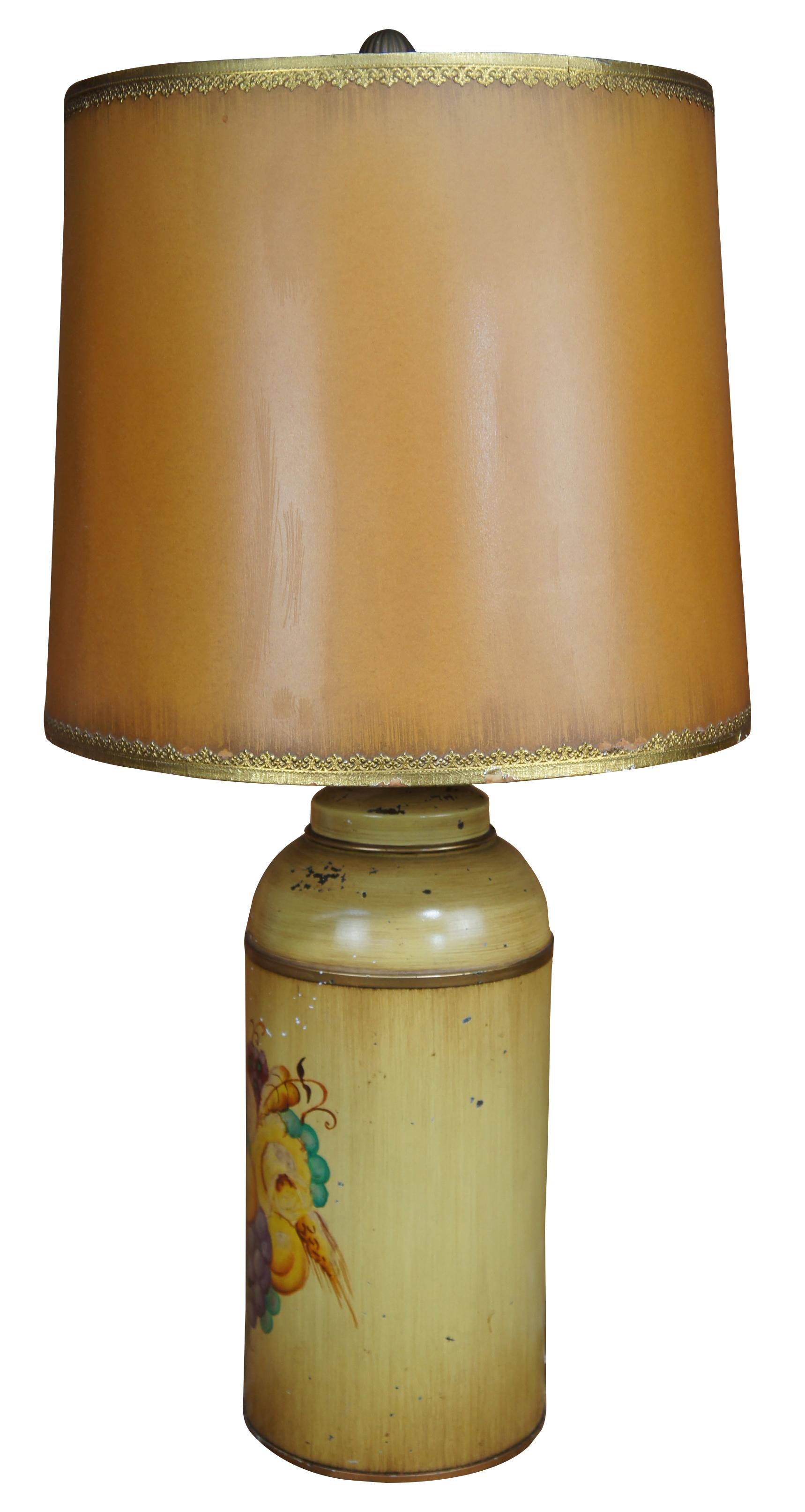 Mid 20th Century tole painted canister lamp. Features a yellow painted body with a still life of fruit along the front and barrel shade with ornate trim. 

Measures:6.25” x 17” / Shade - 14” x 12” / Total Height – 27.75” (Diameter x Height).