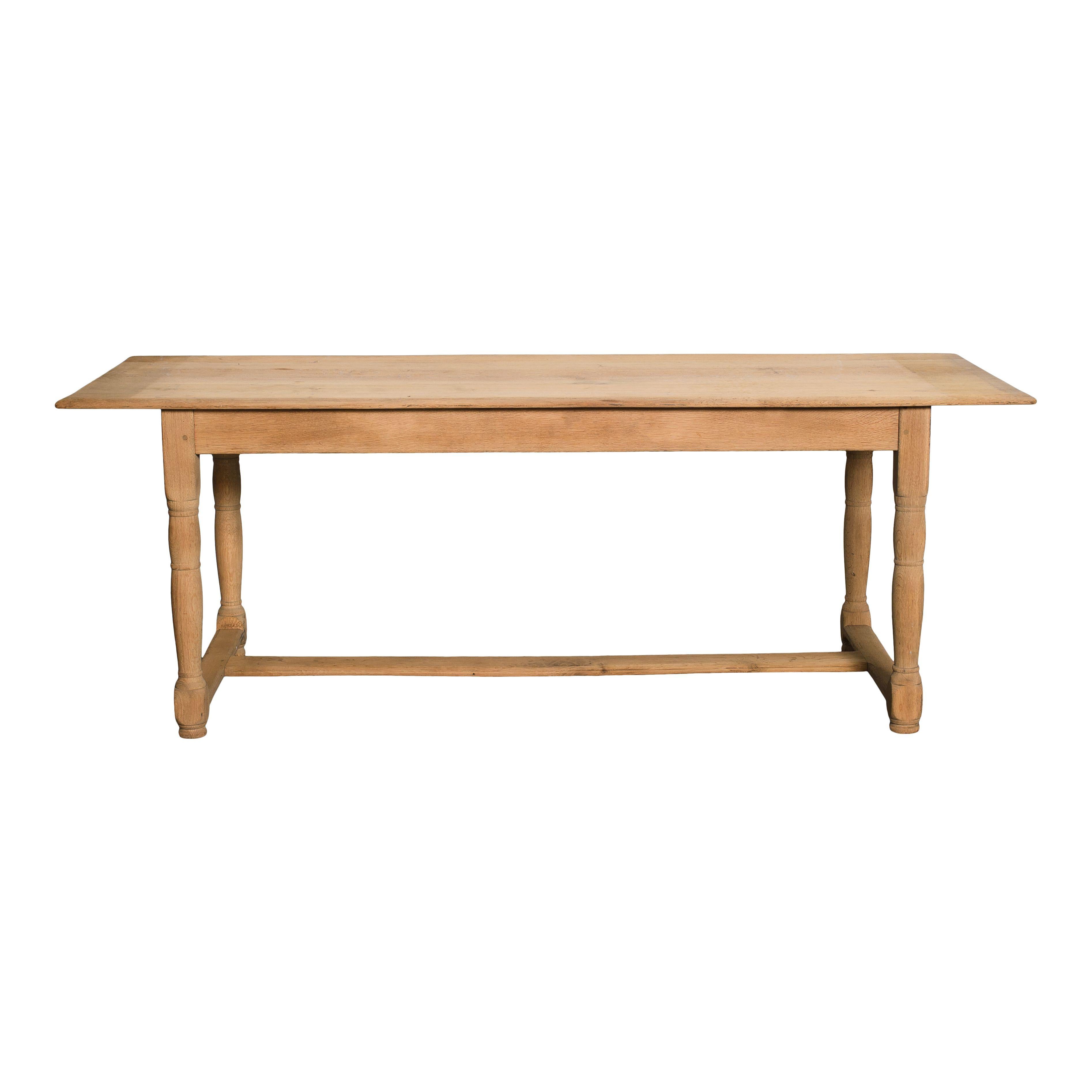 Table de salle à manger vintage en bois sablé de Belgique. Le bois clair et sa finition douce rendent cette pièce chaleureuse et accueillante. Le simple plateau rectangulaire et les quatre pieds reliés par des traverses, confèrent à la table une