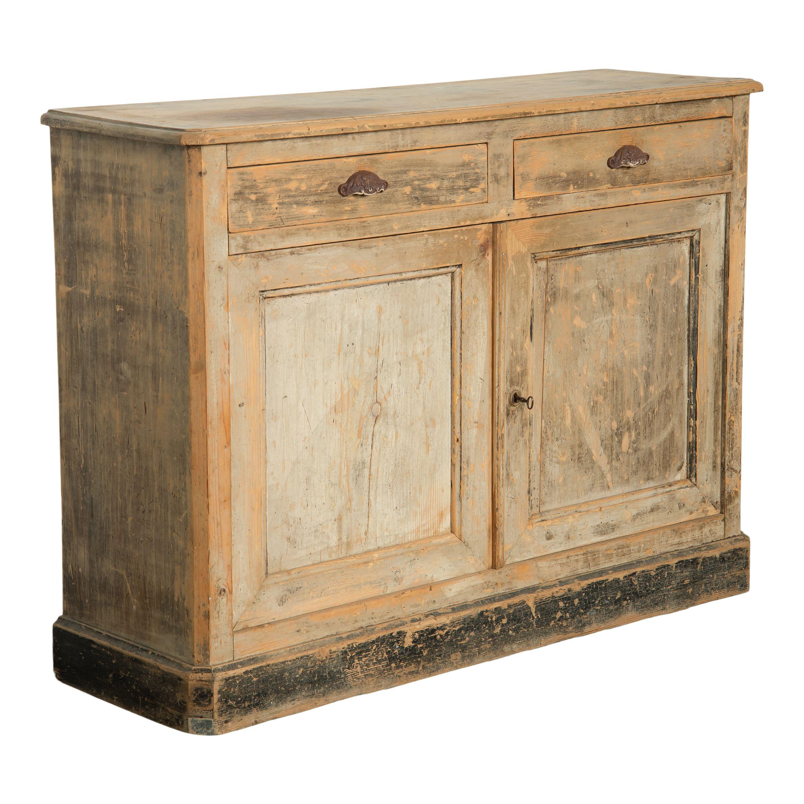 Vintage French wood cabinet with shelves and drawers. The cabinet is a simple square shape with two small drawers at the top and two doors that open to a shelf and storage space. The chipped paint gives this piece a lovely vintage patina that shows