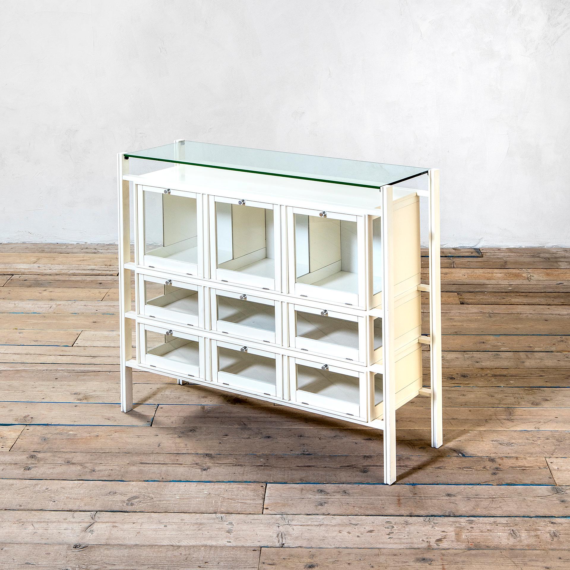 Vitrine designed by Carlo De Carli in 1941 for Italia Production. The structure is in white lacquered wood, the front of the credenza has nine shelves that could be opened through flap doors. Perfect for showing personal collection or for the dining